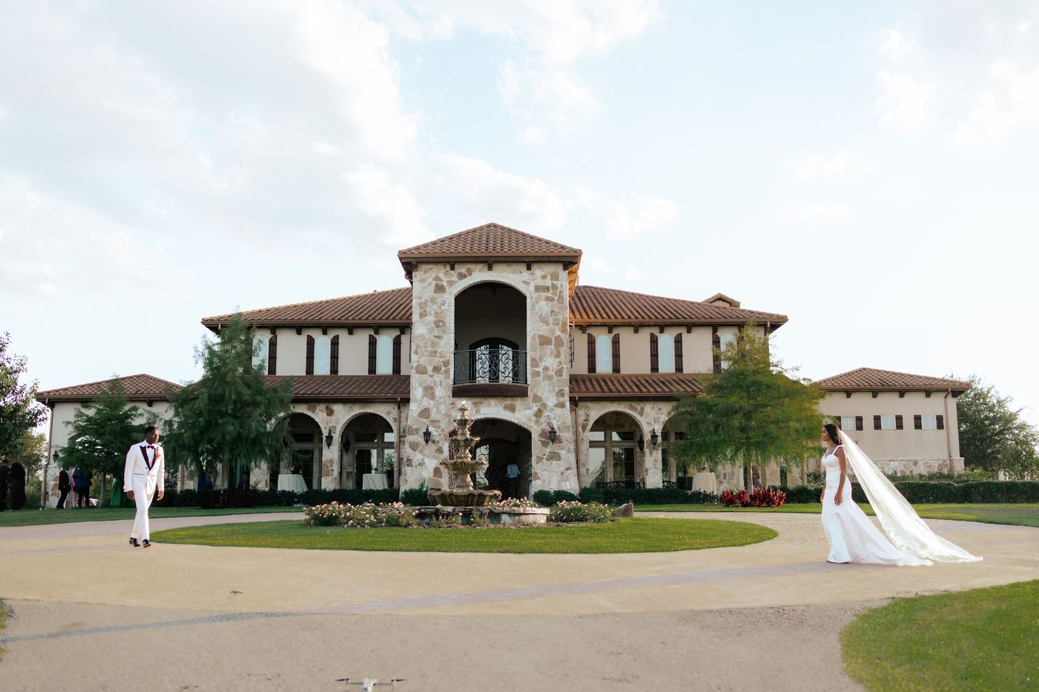 Panoramic view of a grand Mediterranean-style wedding venue with manicured grounds.
