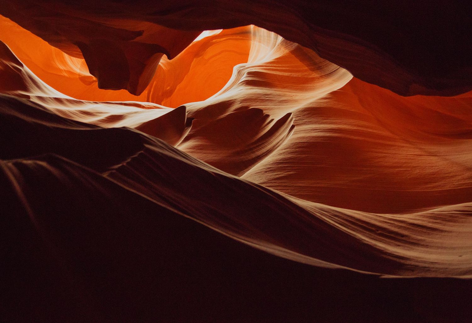 Stunning Antelope Canyon slot canyon with glowing orange and red sandstone waves illuminated by natural light.