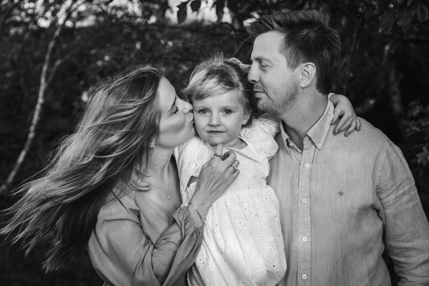 A black and white photo collage shows tender family moments between parents and child in an outdoor setting.