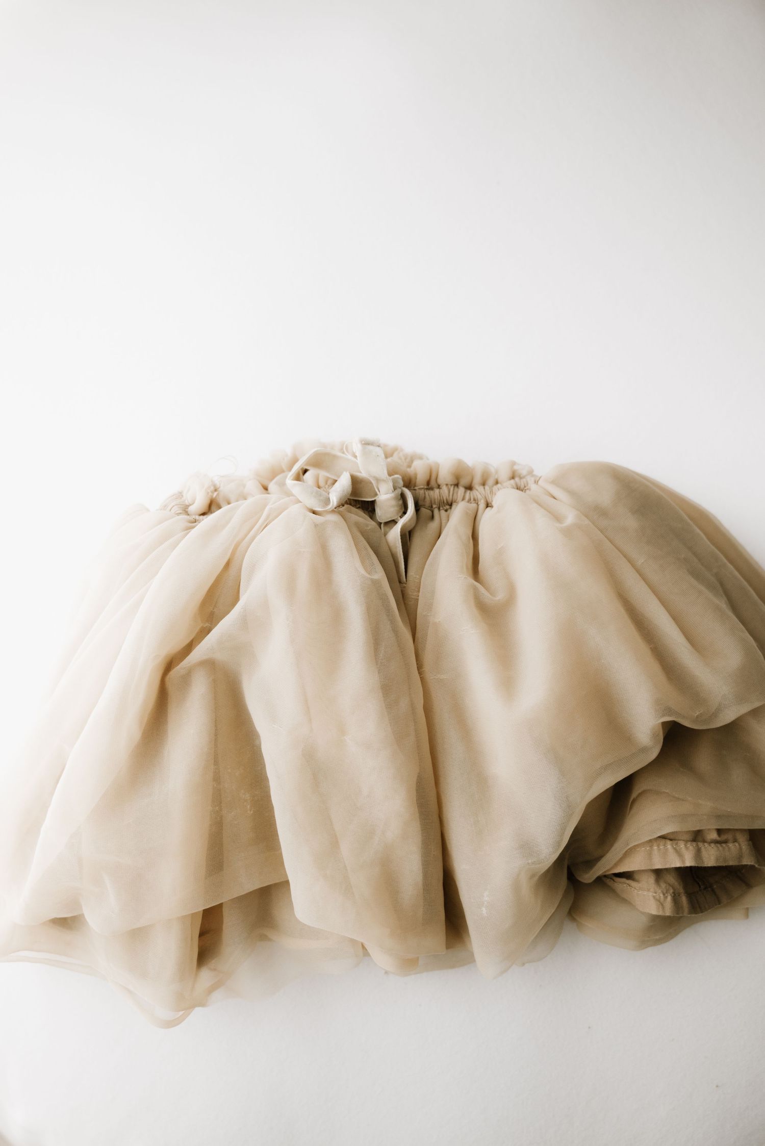 Ethereal beige tulle skirt with gathered waistband photographed against white background.