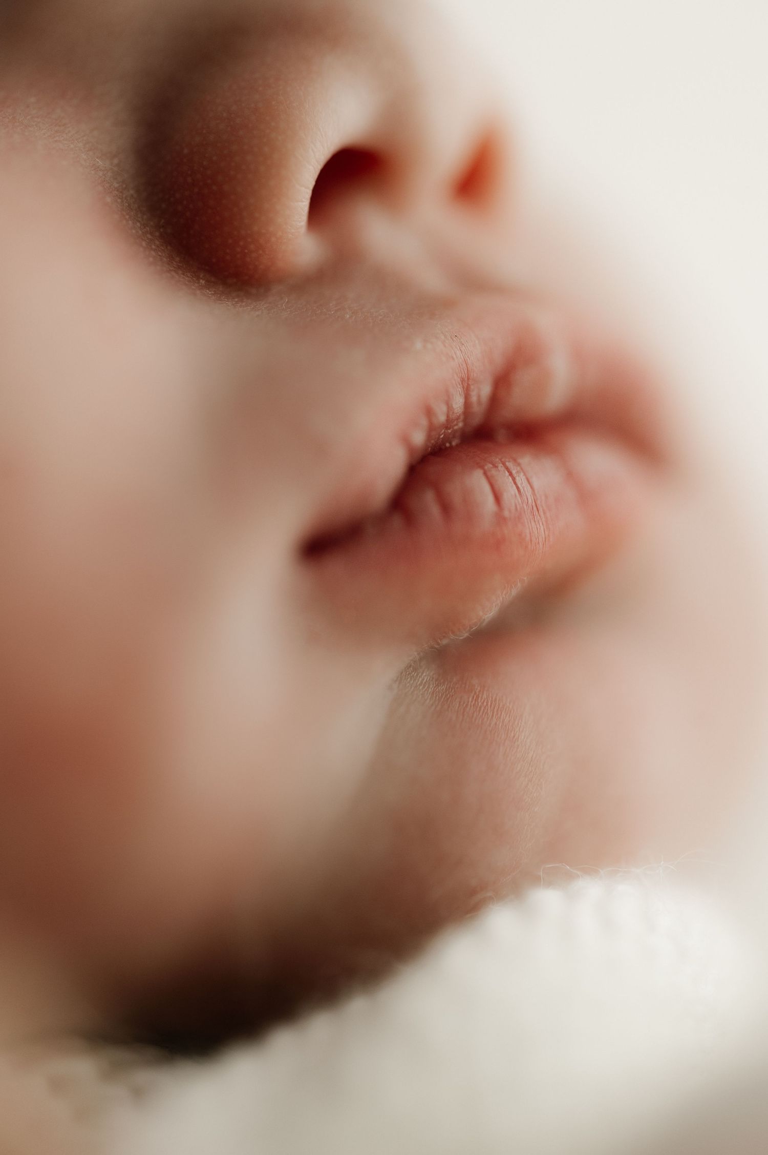 Ethereal macro close-up of sleeping baby's nose and lips.