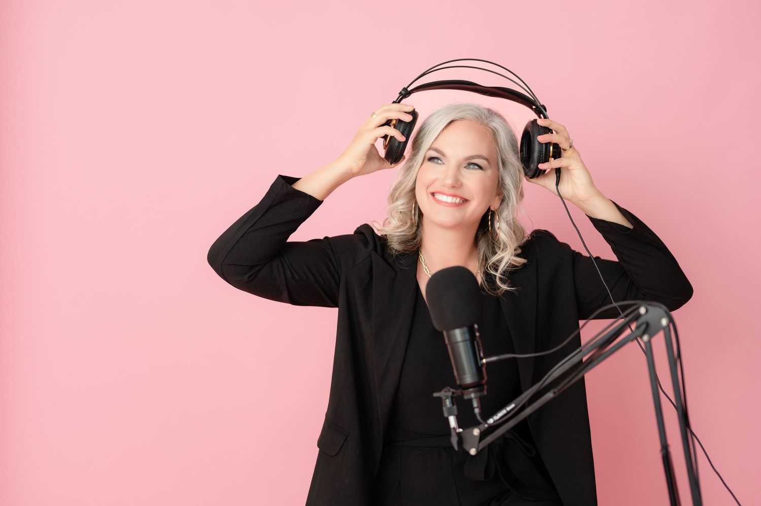 Professional model wearing black headphones poses against pink background in various animated expressions.
