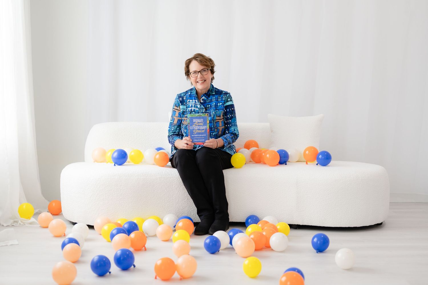 A sequence showing colorful balloons popping in a white studio space while someone watches from the background.
