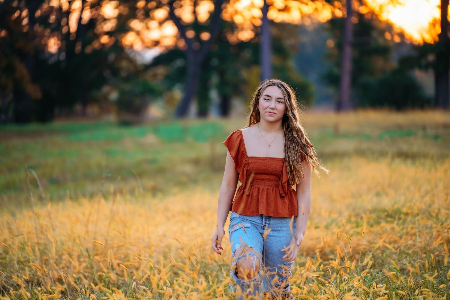 Senior portrait in rustic setting during golden hour with warm autumn colors.
