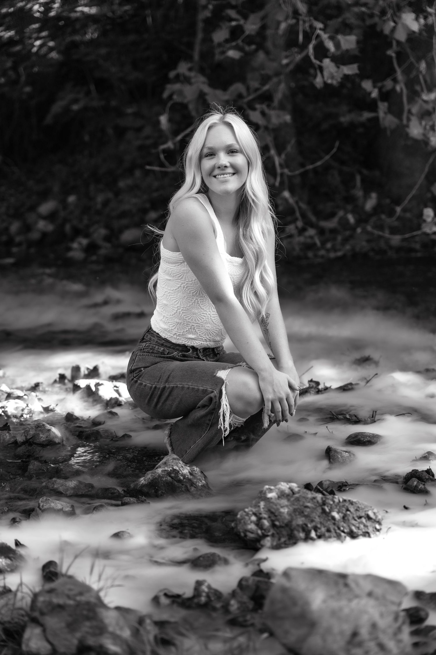 Black and white photo series of a person laying in dappled sunlight on the ground, creating artistic shadow patterns.