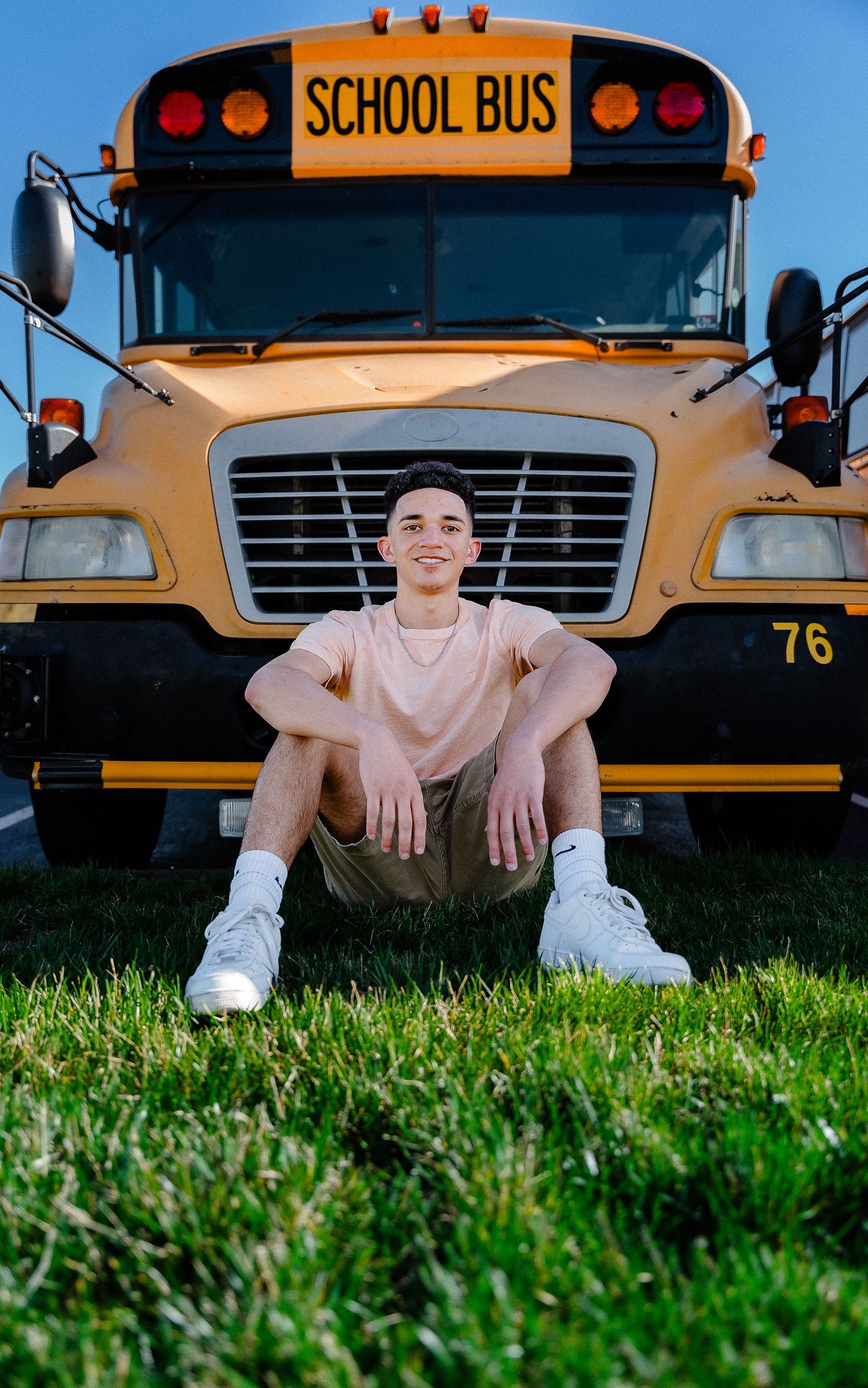 A series of creative photos showing someone sitting in green grass in front of a yellow school bus.