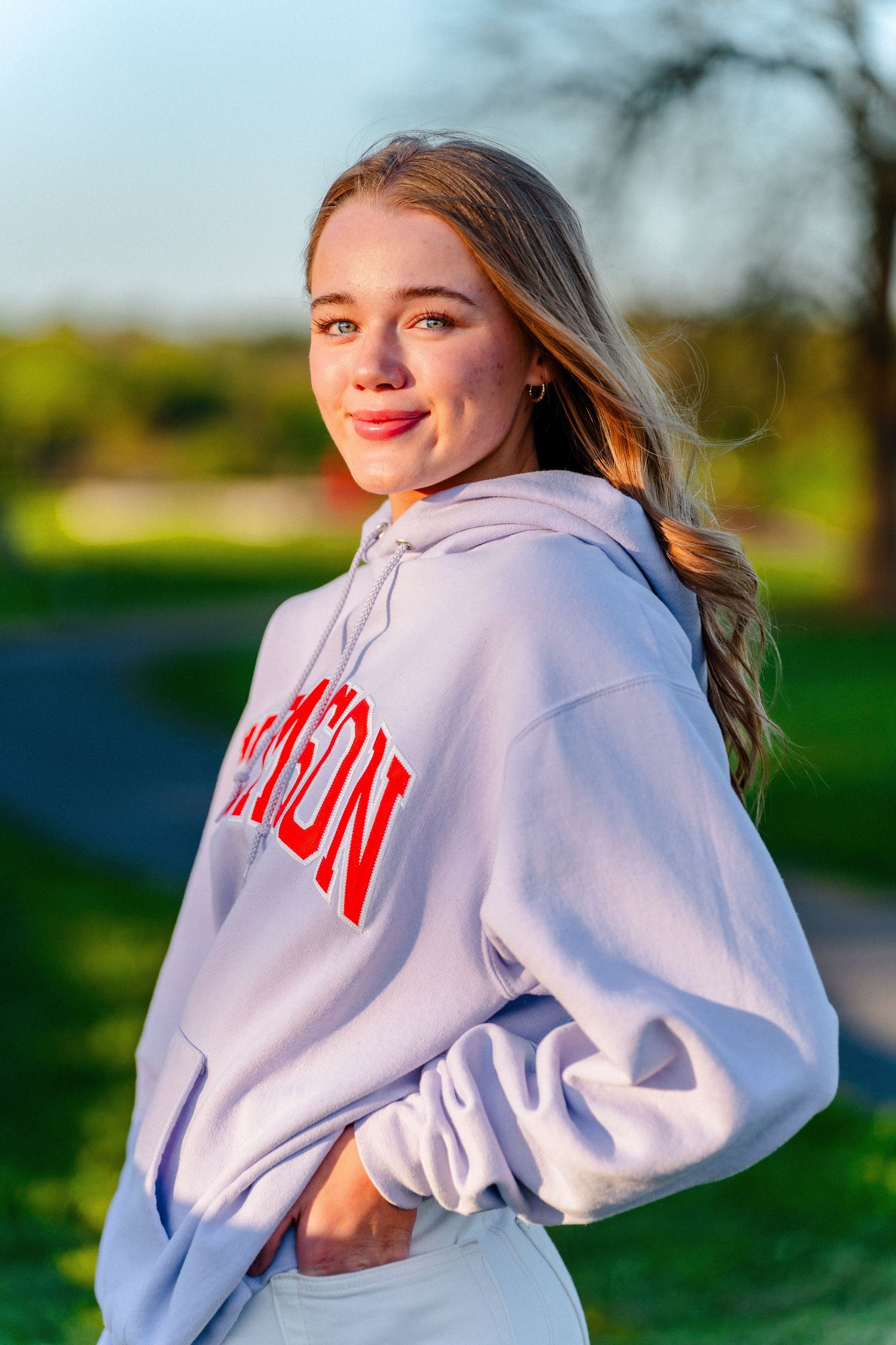 White university sweatshirt photographed in golden hour lighting outdoors.