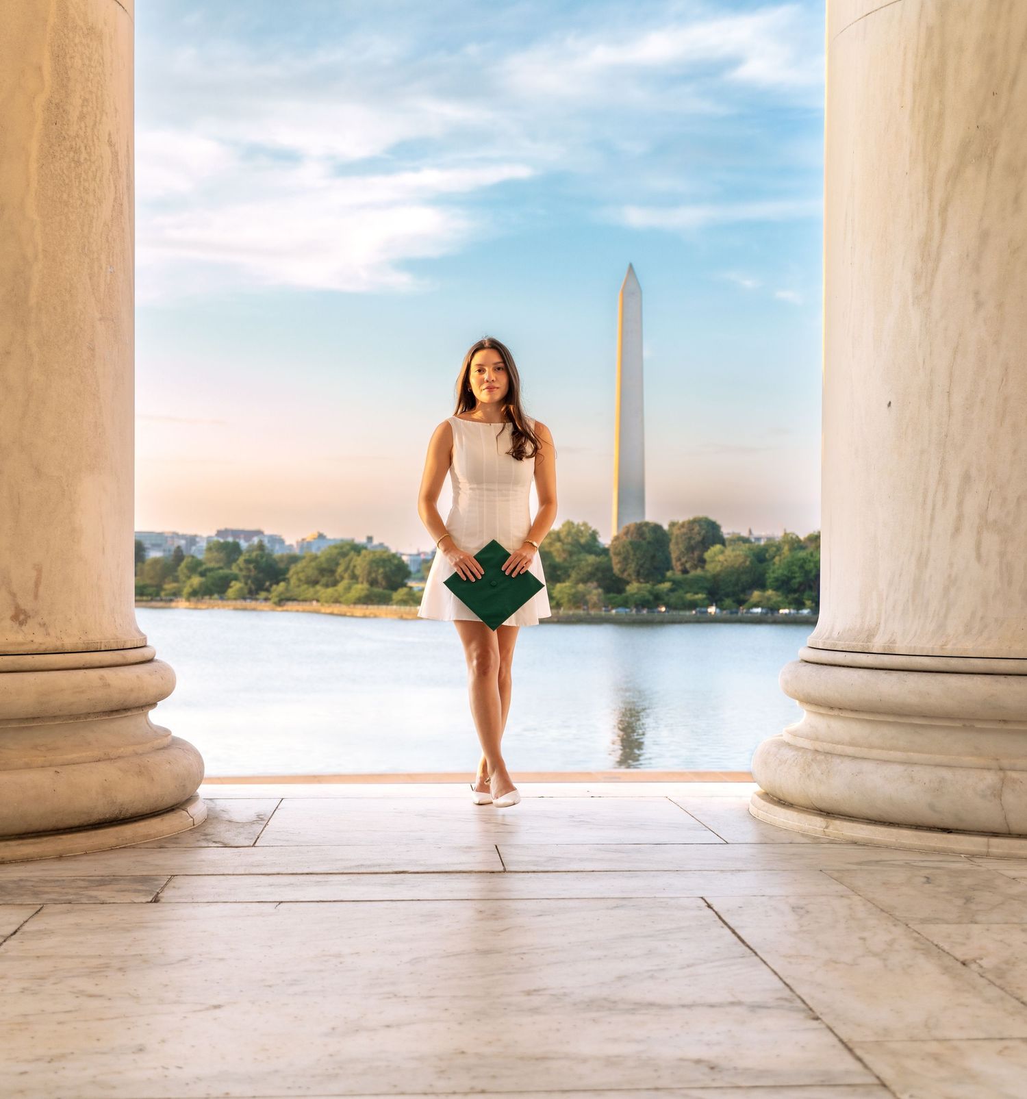 View of the Washington Monument through white marble columns on a sunny day.