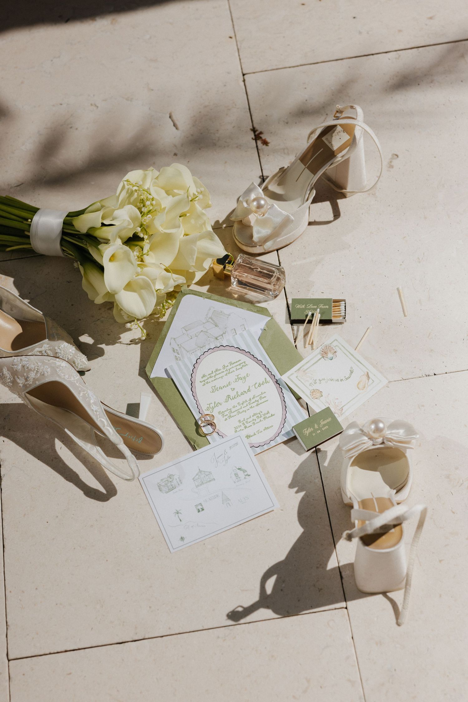 Wedding invitations and floral details arranged on white surface with elegant shadows creating romantic composition.