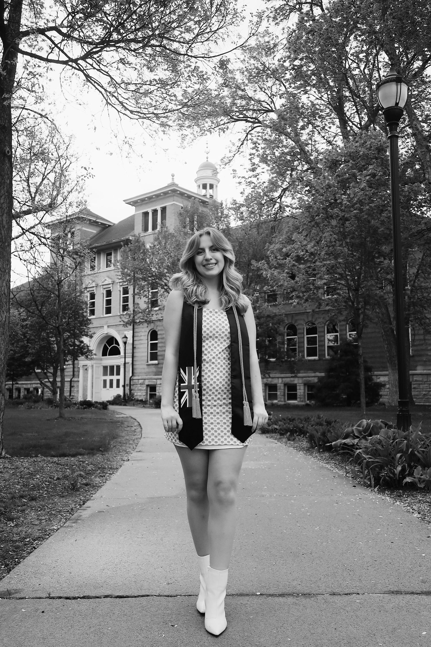Graduate standing in front of her university for photoshoot