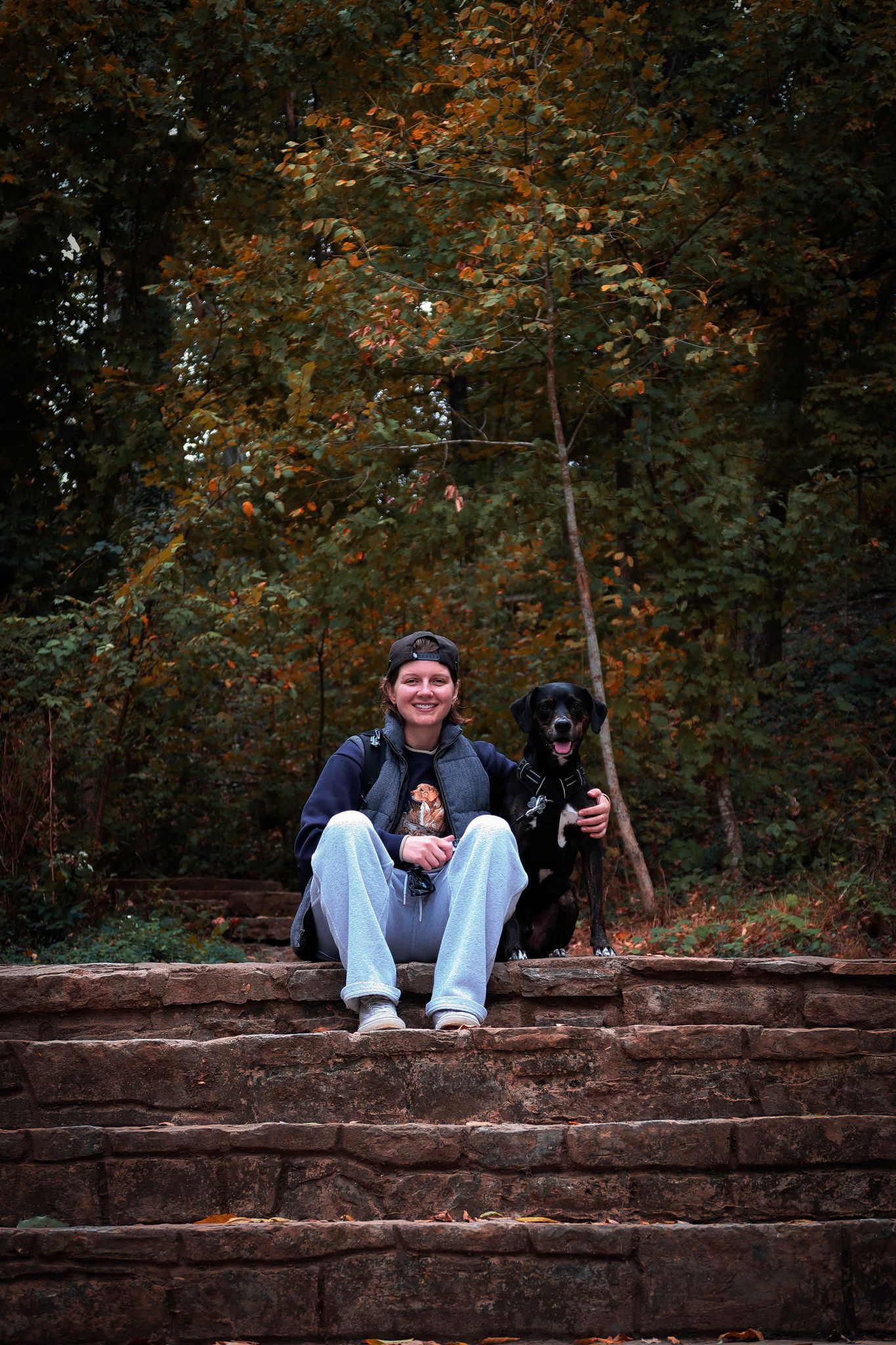 girl and her dog sitting on stairs smiling for a photo for photoshoot