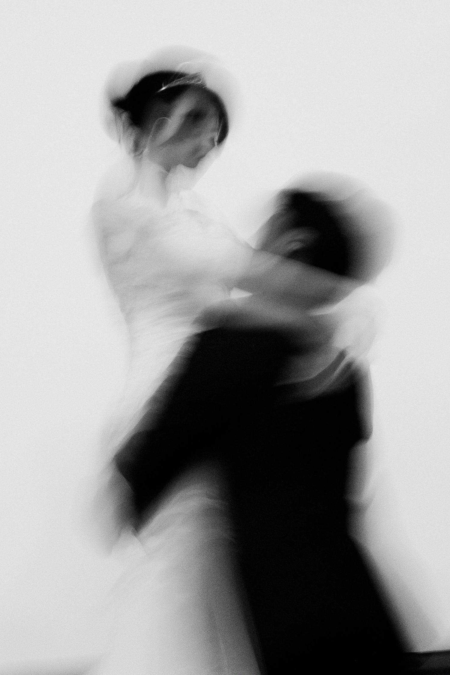 Dramatic blurred motion black and white image of couple sharing first wedding dance.