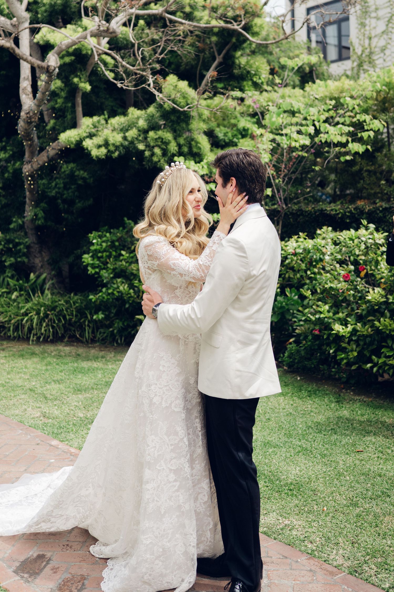 Bride and groom embrace tenderly in lush garden during emotional first look wedding moment.