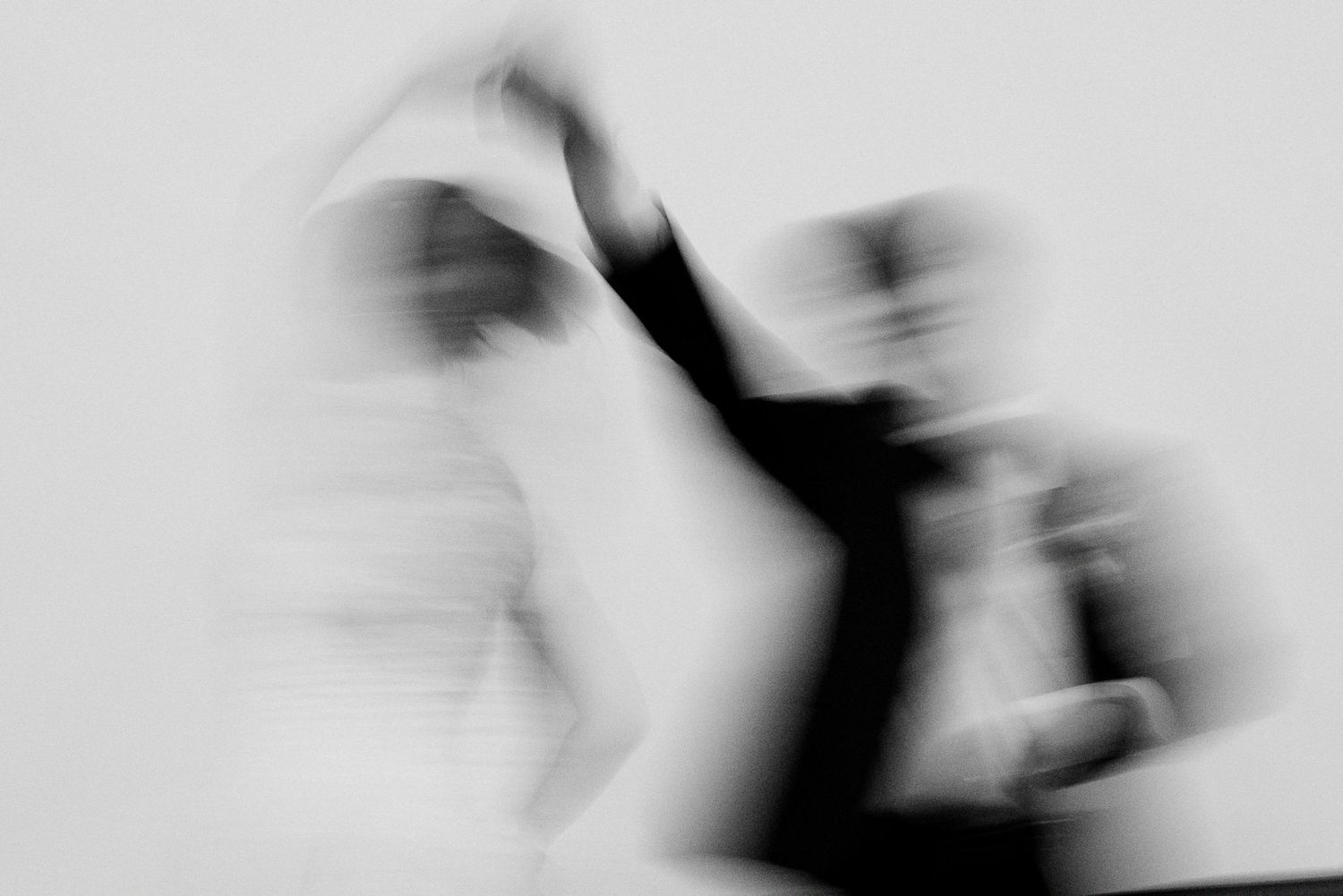 Blurred black and white motion photo of wedding couple dancing.