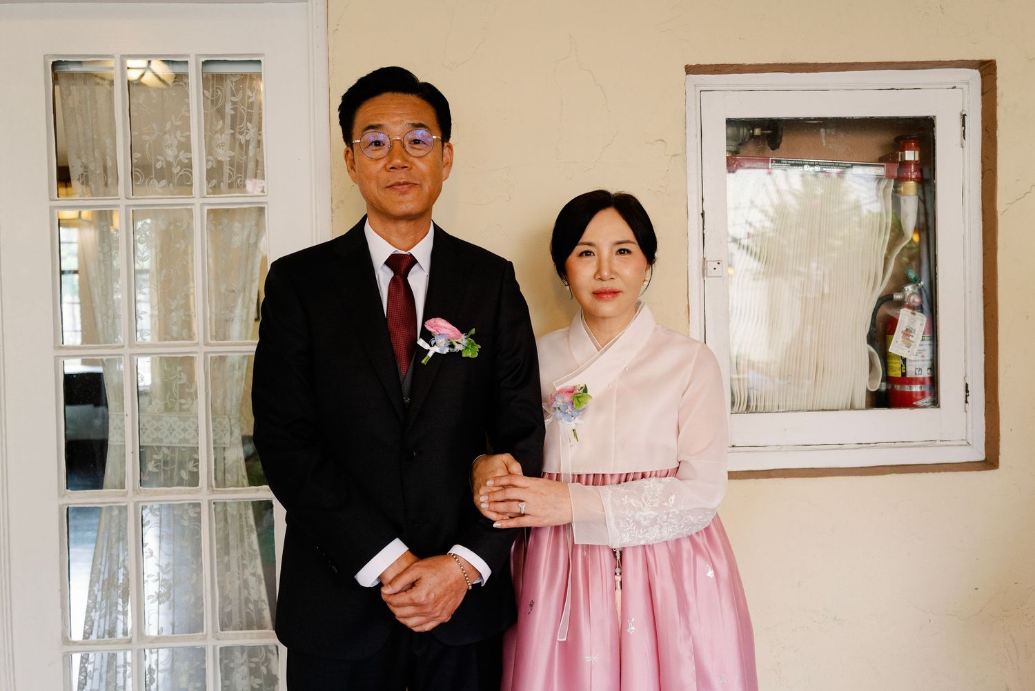Couple posing in traditional Korean hanbok attire during wedding celebration.