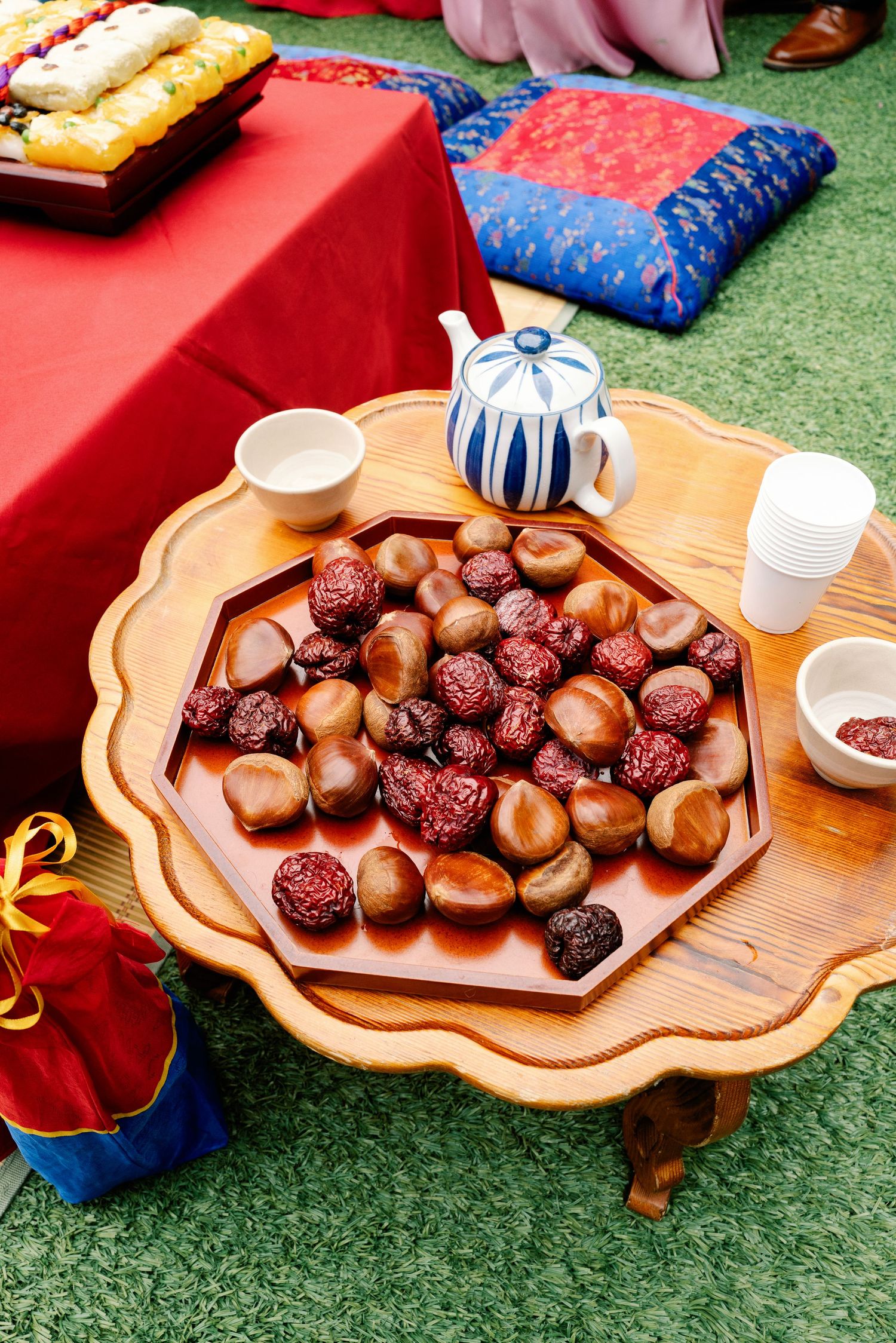 Traditional Korean wedding paebaek table with jujubes and chestnuts on ornate wooden tray.