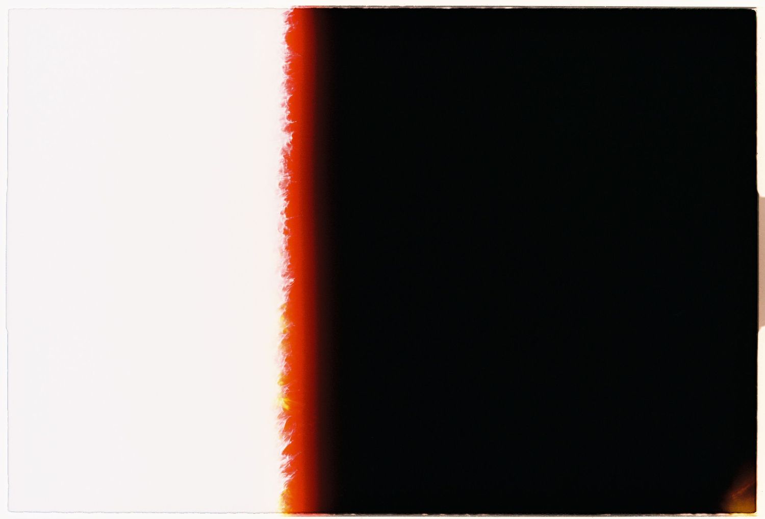 Abstract film photography image showing a gradient from white to deep black with a burnt orange edge transition.