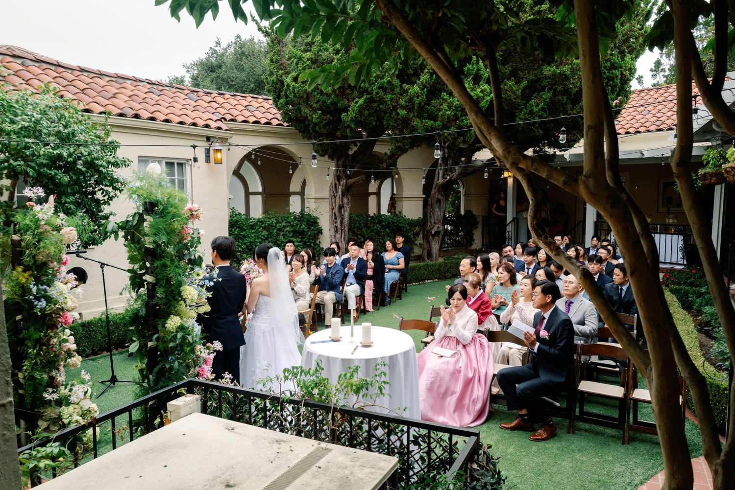 Bride and groom stand at the altar during an intimate outdoor garden wedding ceremony.