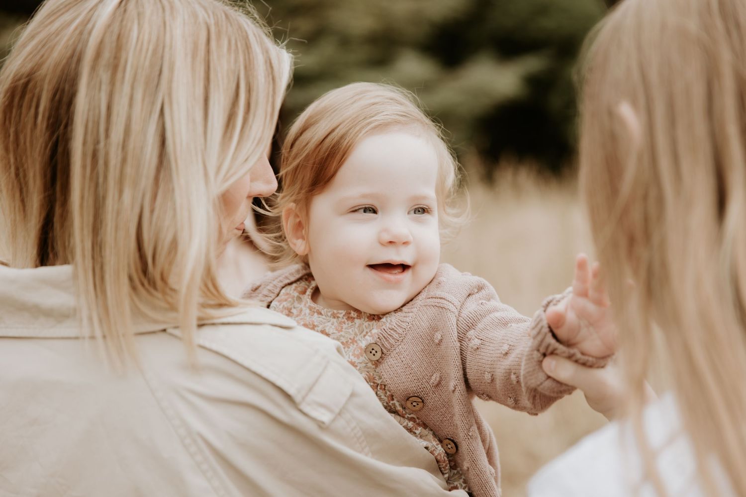 Mother and child laughing together in soft sepia toned outdoor portrait.