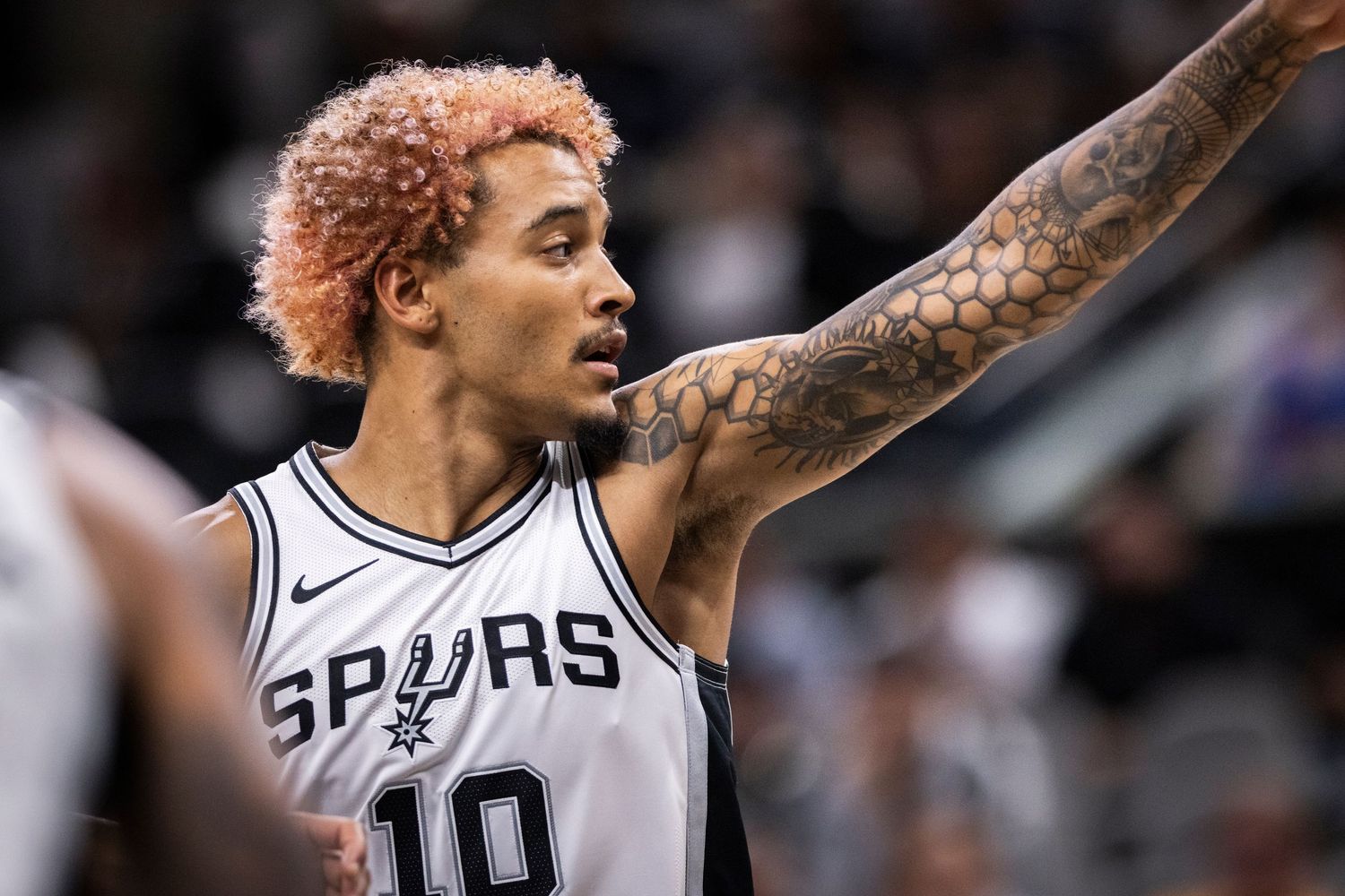 Basketball player in Spurs jersey gestures during NBA game.