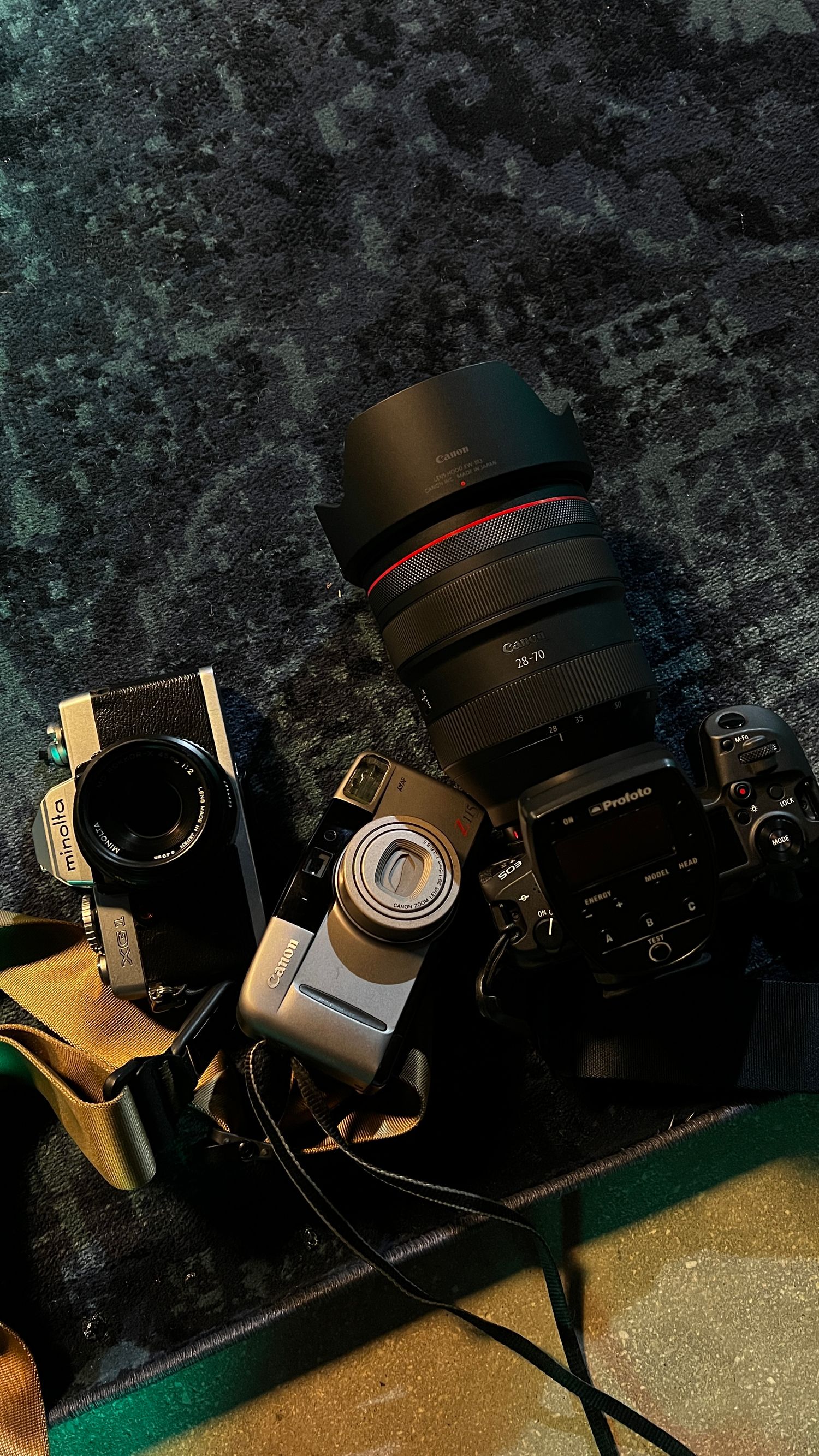 A sequence of four moody photographs showing a black camera rotating against a dark textured background.
