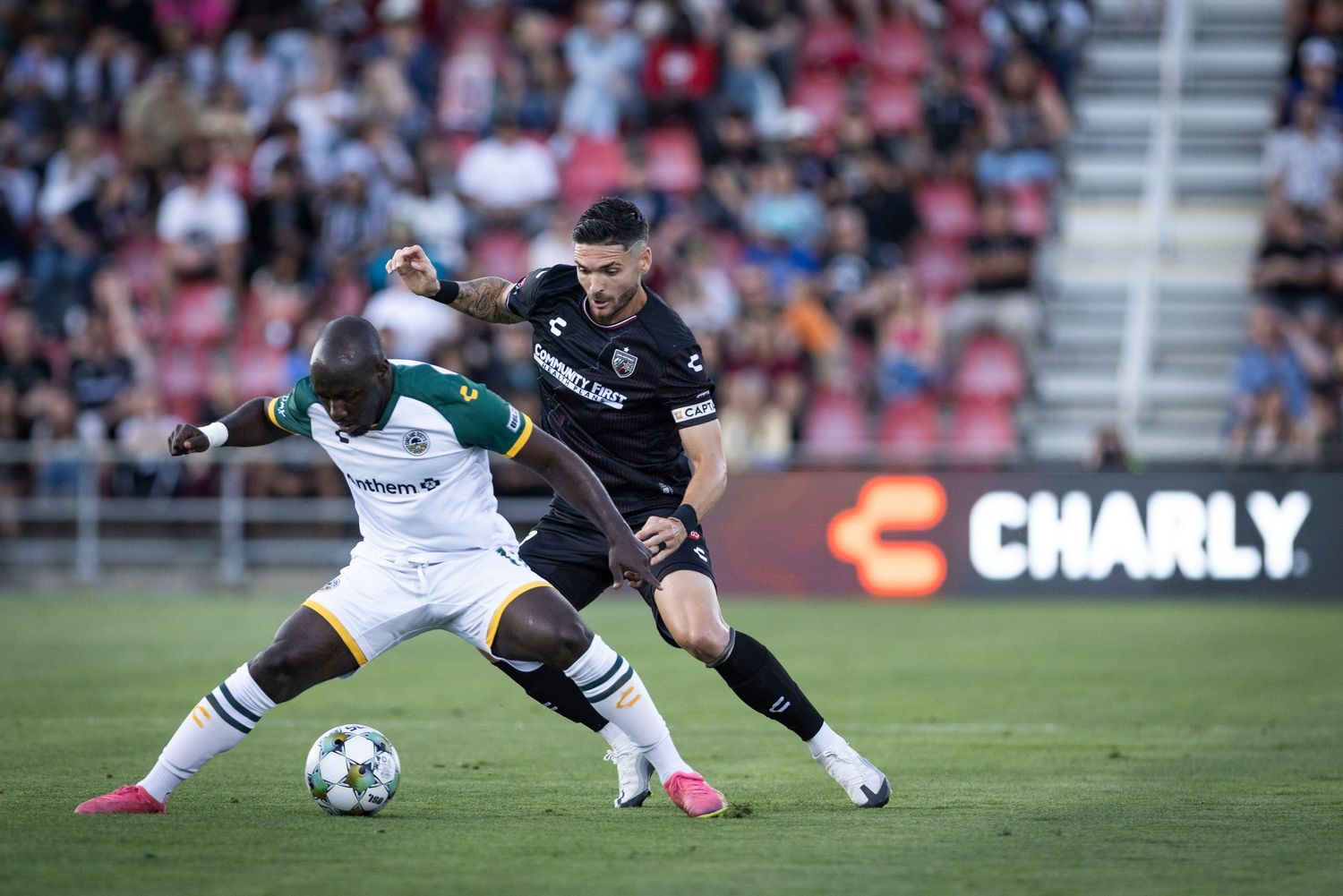 Soccer players battle for ball possession during an intense match.