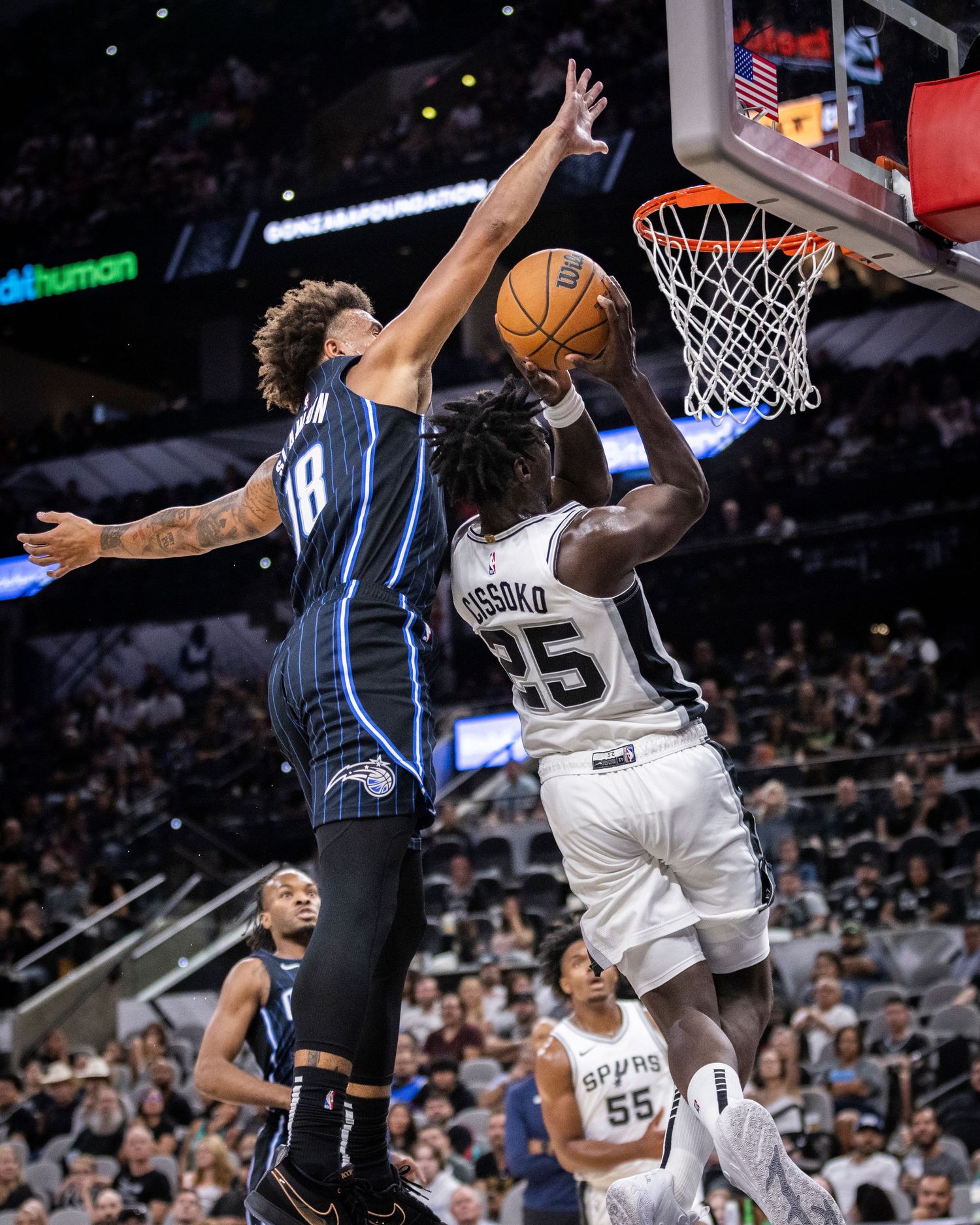 Basketball players battle for position under the hoop during a game.