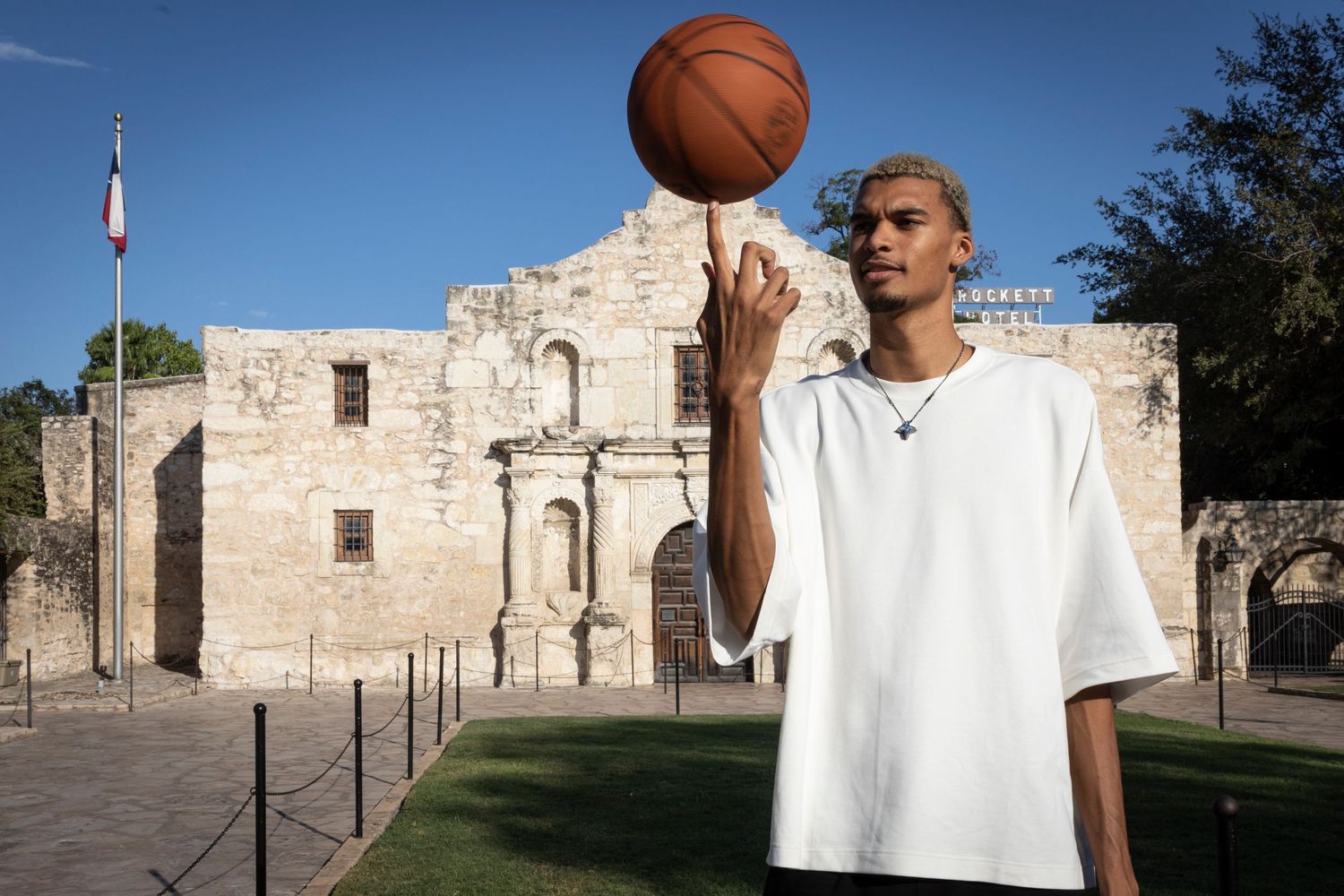 Young man spinning a basketball on his finger in front of the historic Alamo in San Antonio, Texas.