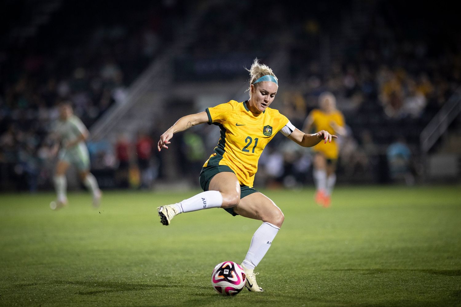 Soccer player in yellow uniform controls ball during match action.