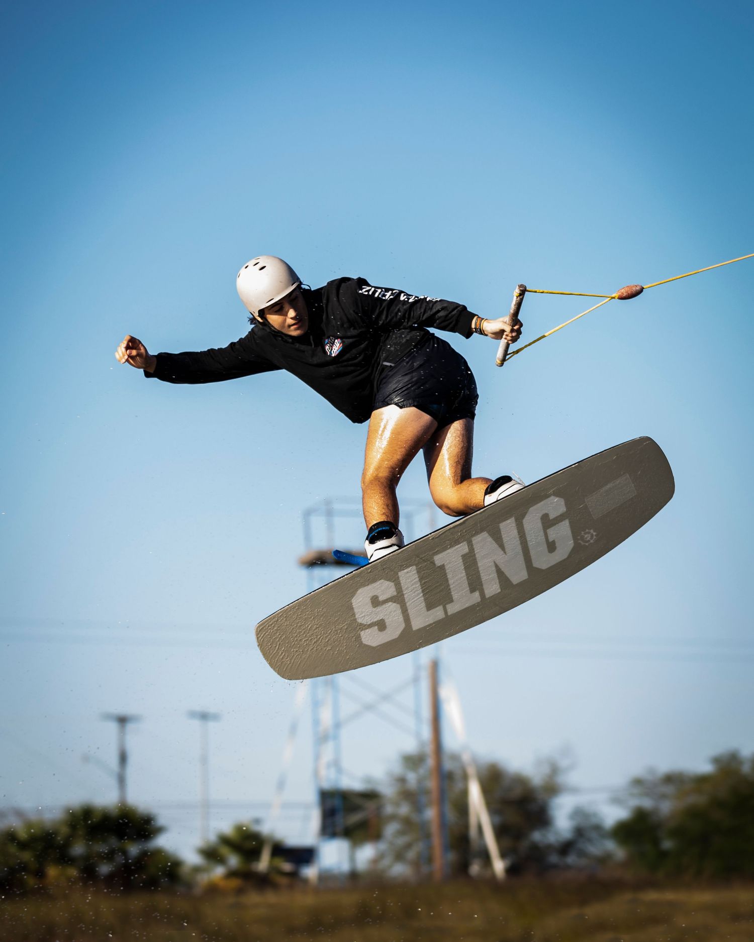 Action shot of wakeboarder performing aerial trick on Sling branded board.