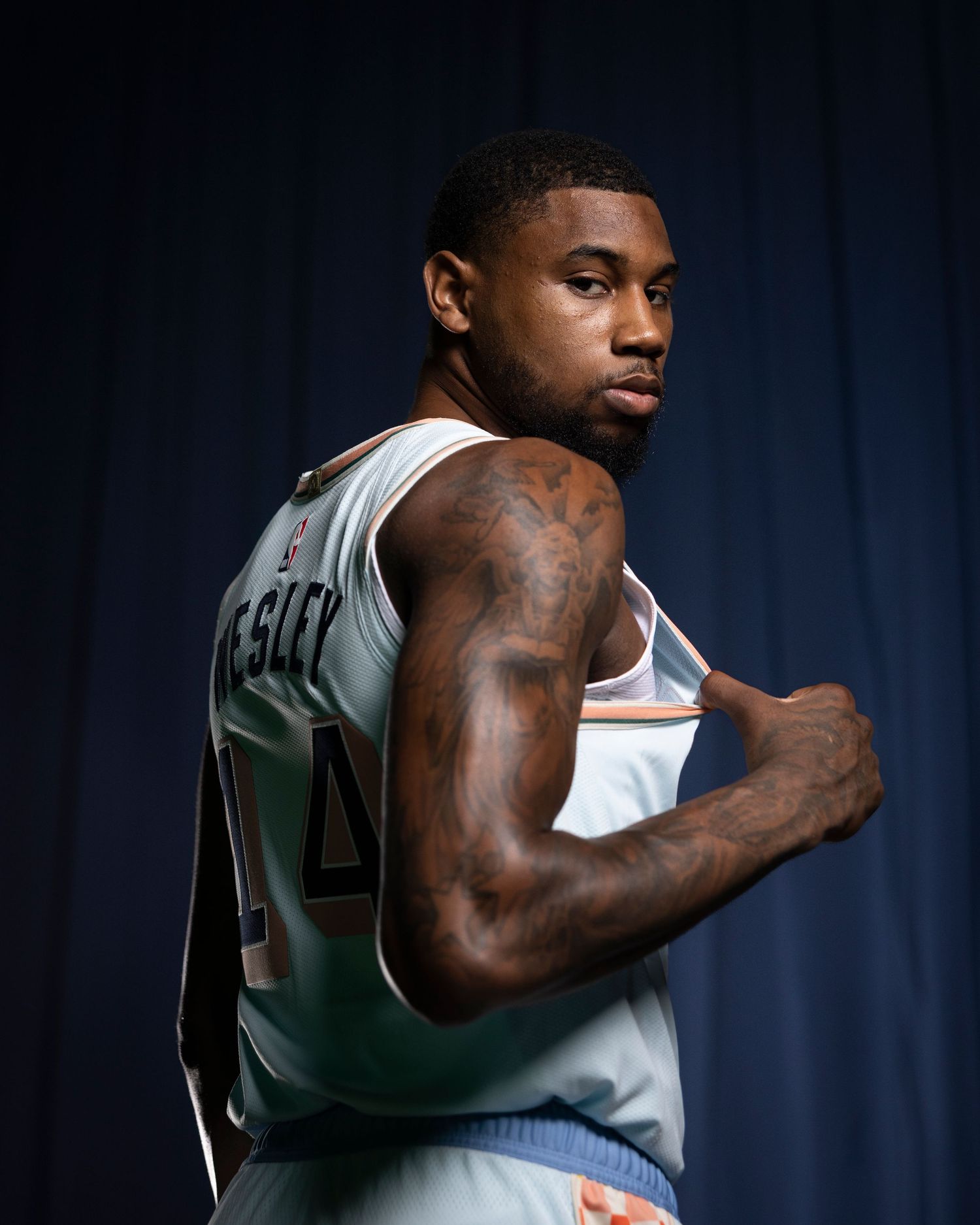 Basketball player in San Antonio jersey shows athletic pose during team photo session.