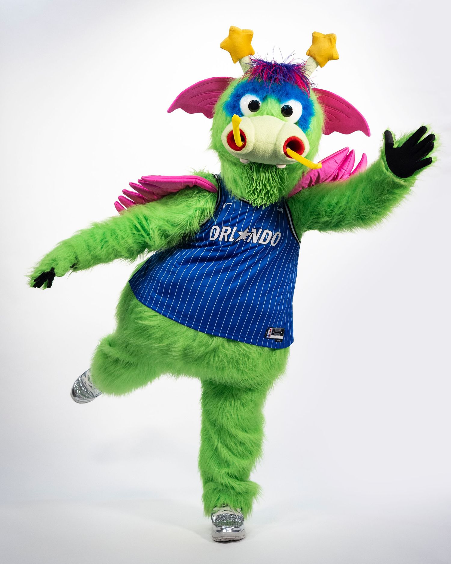 Orlando Magic NBA mascot Stuff the Magic Dragon in green fur costume wearing blue pinstripe Orlando jersey.