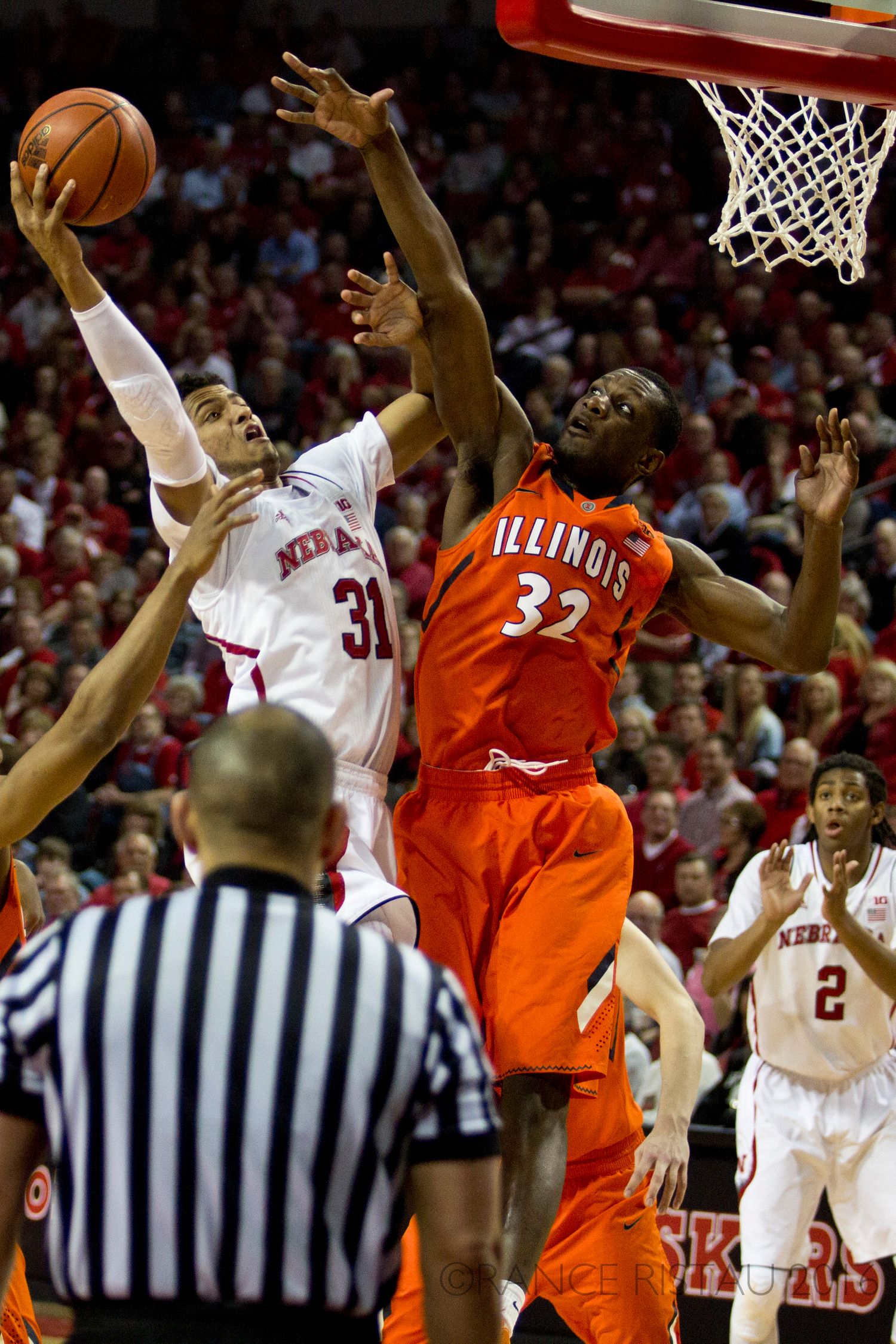 Basketball players competing for rebound during intense game between Nebraska and Illinois.