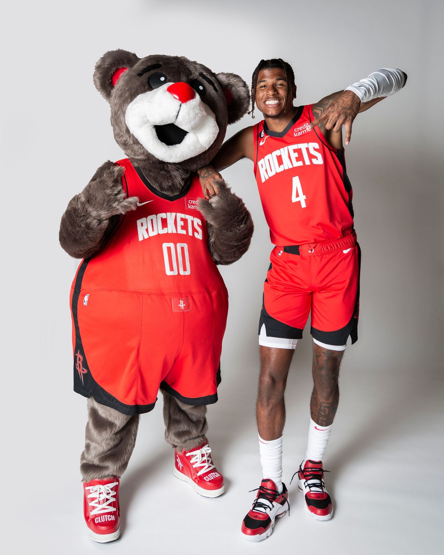 Houston Rockets mascot in team jersey posing with basketball player in studio setting.