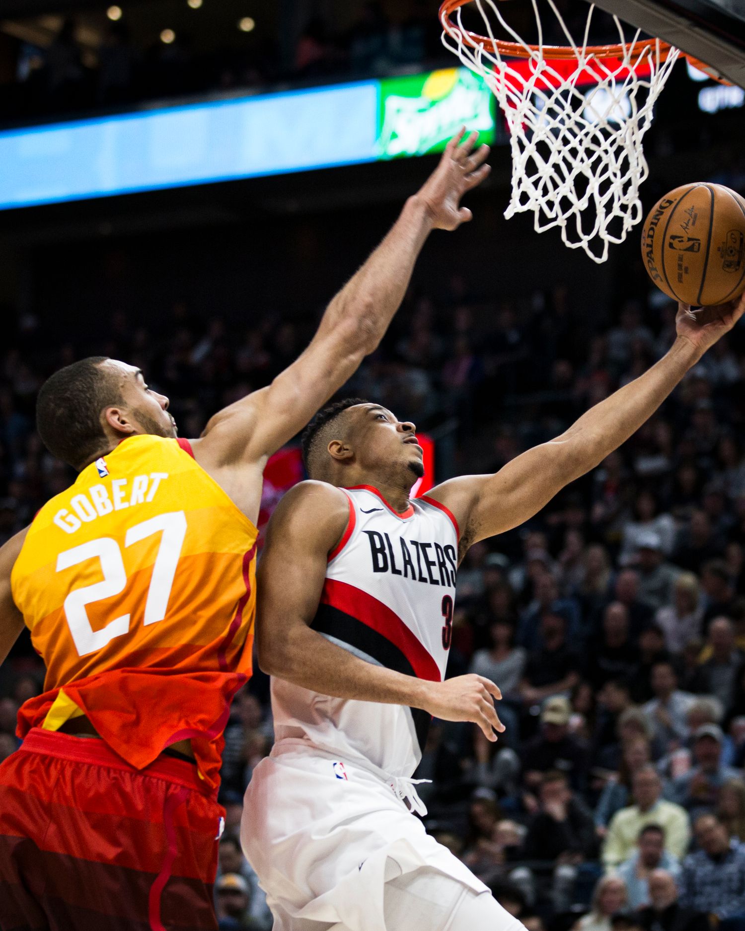 Two basketball players compete for a layup during intense NBA game action.