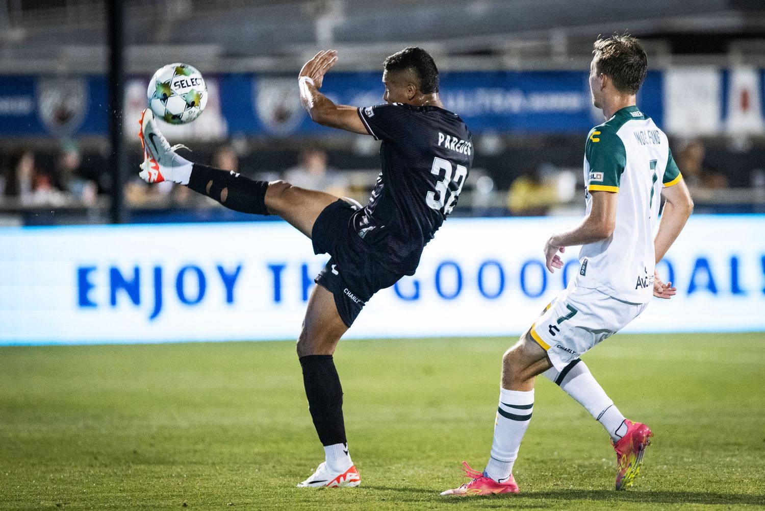Soccer player performs an acrobatic high kick during a competitive match.