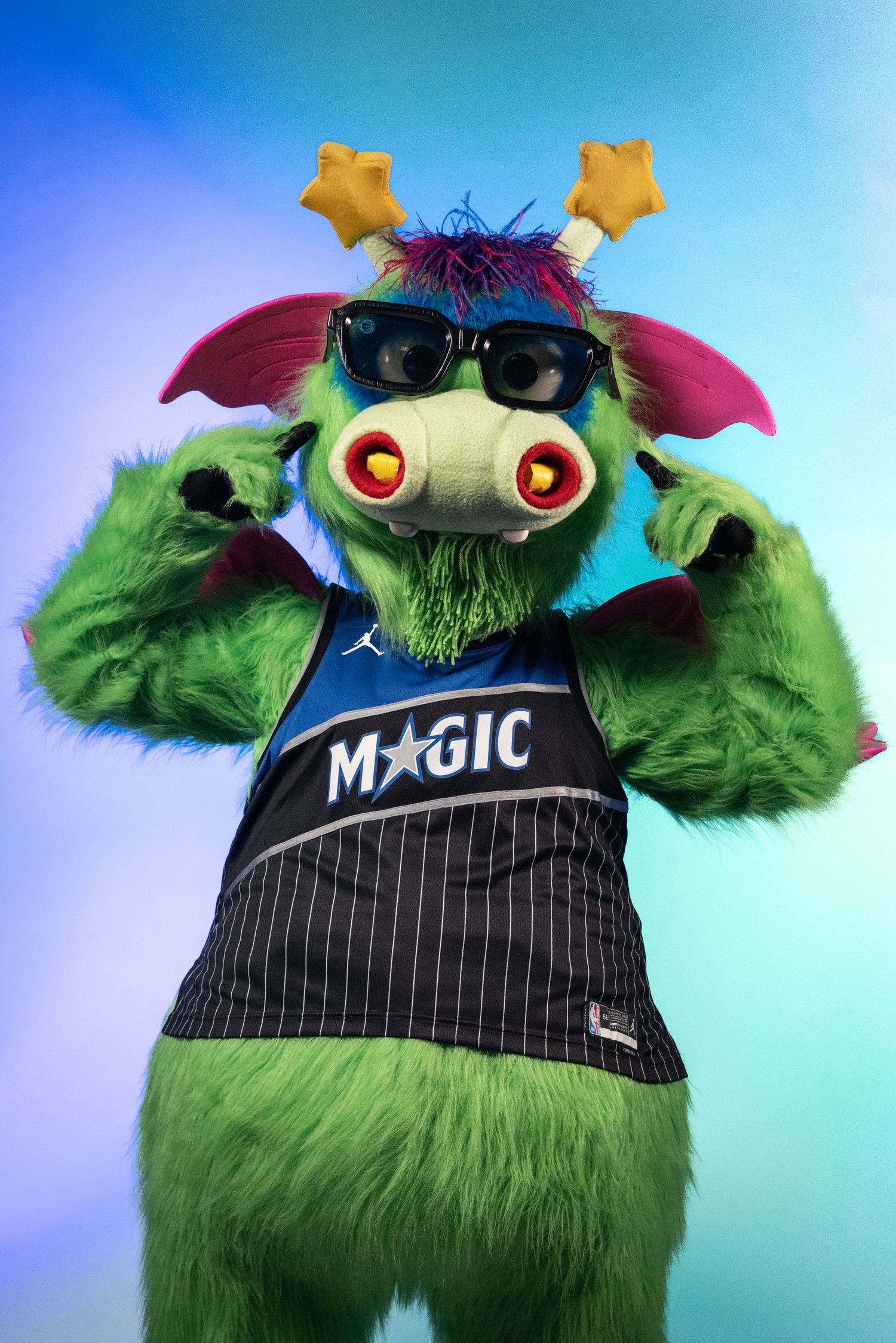 Orlando Magic mascot Stuff the Magic Dragon in green fur costume wearing sunglasses and Magic jersey.