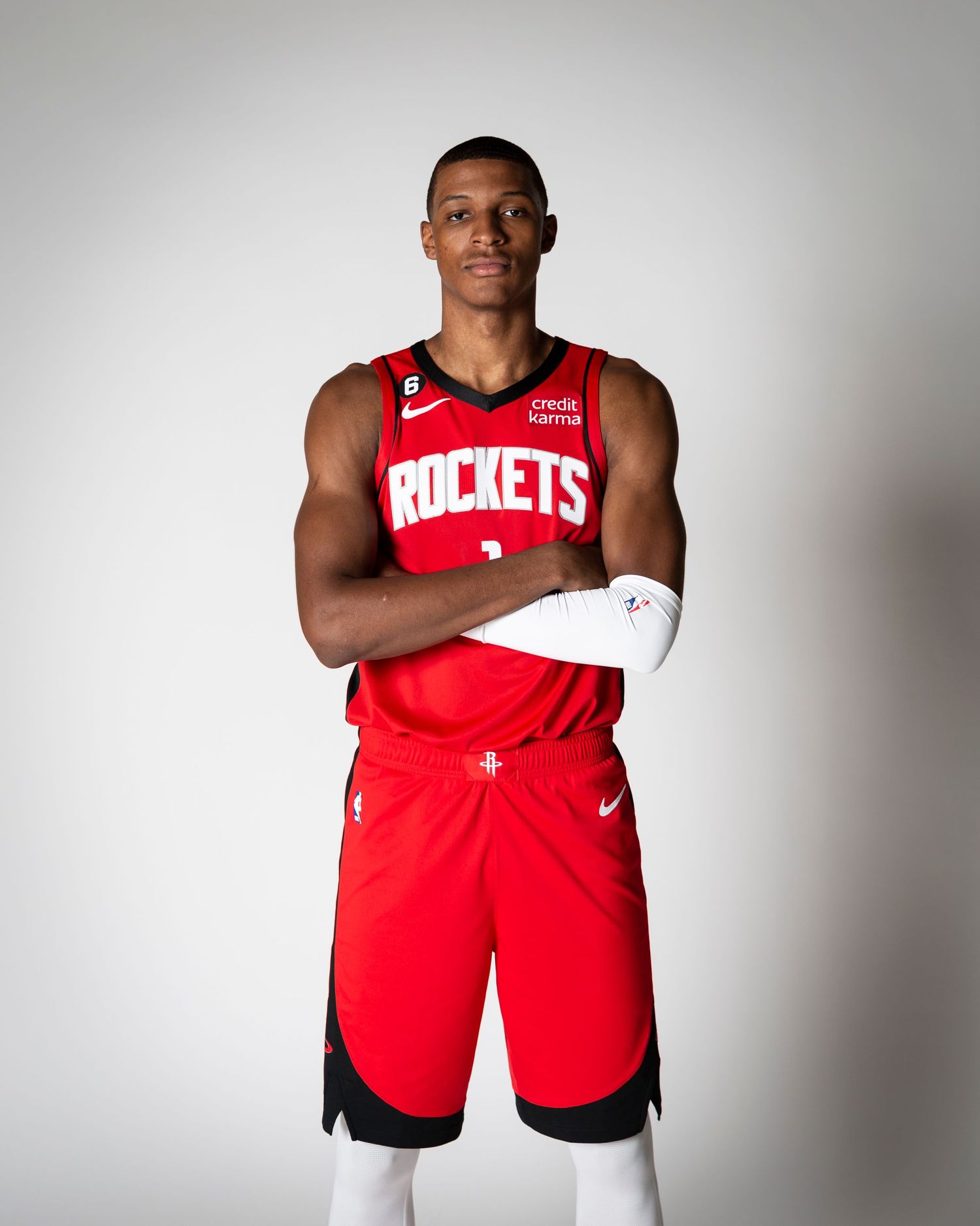 Houston Rockets player stands in official red uniform against white background during media day.