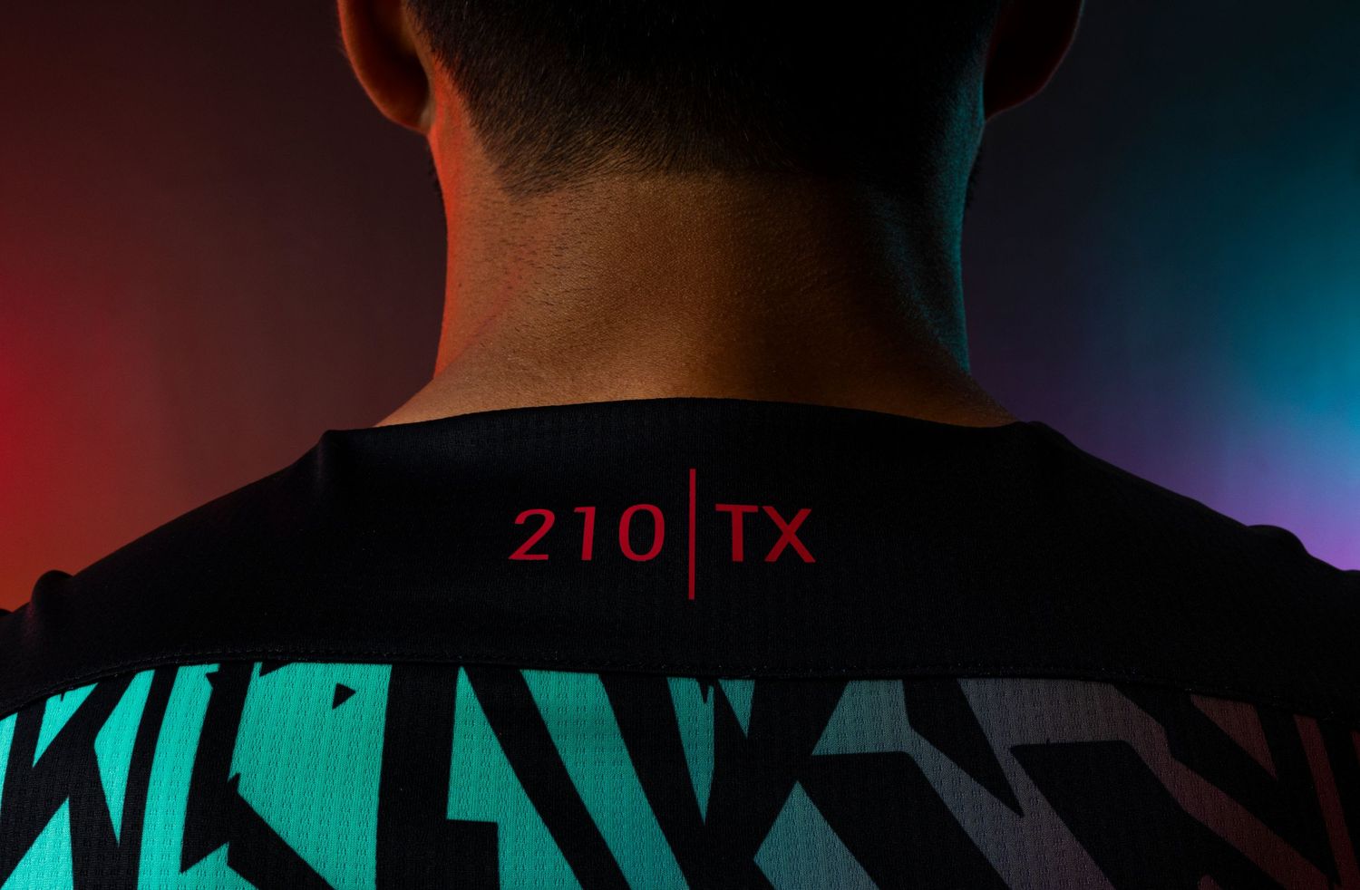 Back view of black jersey with '210 TX' text against colorful lighting.