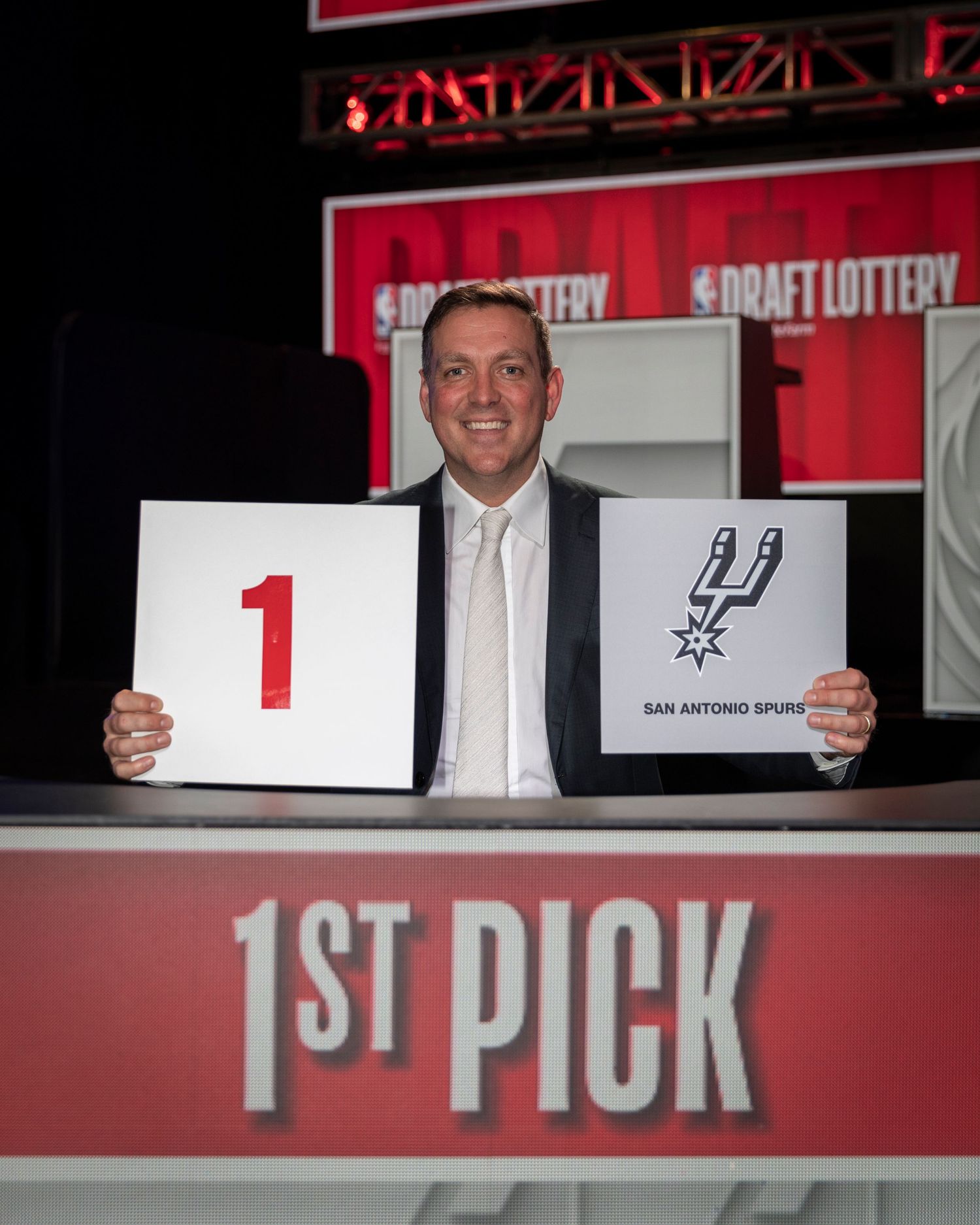 NBA draft lottery representative holds up number 1 pick sign with Spurs logo. Peter J. Holt