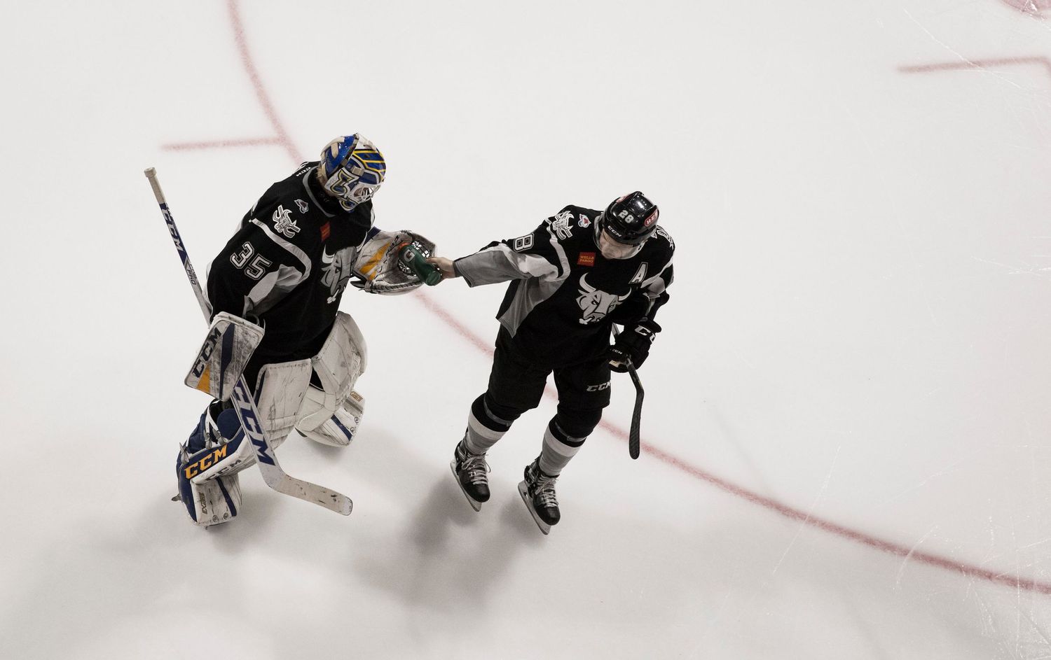 Hockey players battle for the puck on ice during a game.