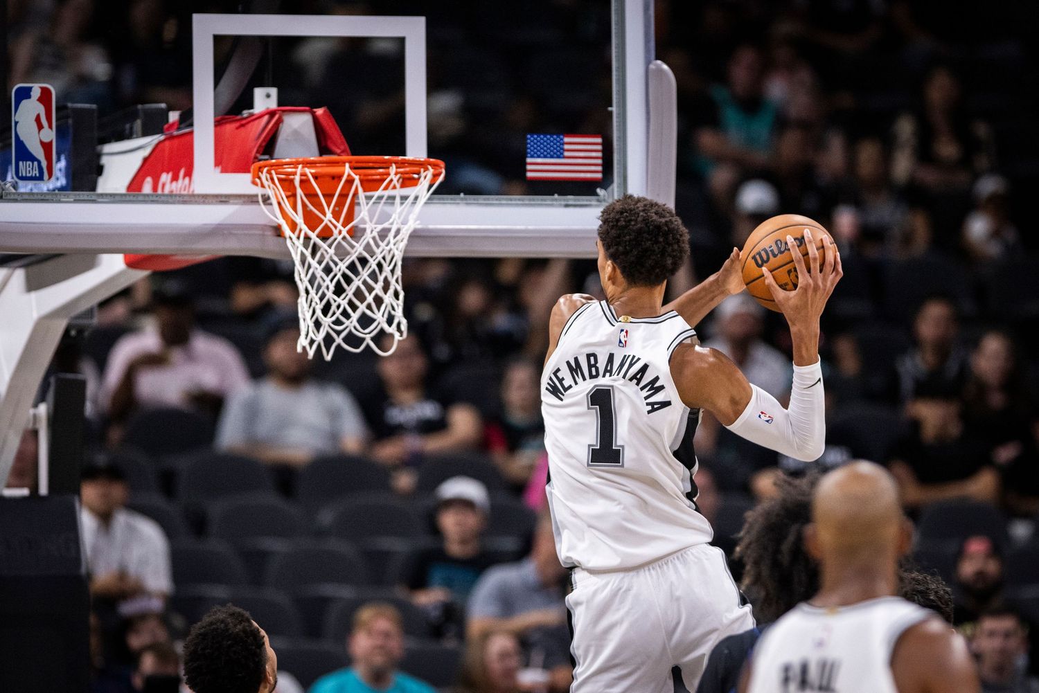 Basketball player in Spurs jersey number 1 goes up for a shot during game. Victor Wembanyama
