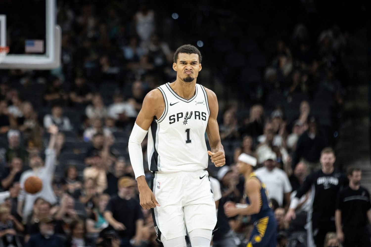 NBA basketball players from the Spurs and Pacers compete for a shot during an intense game.