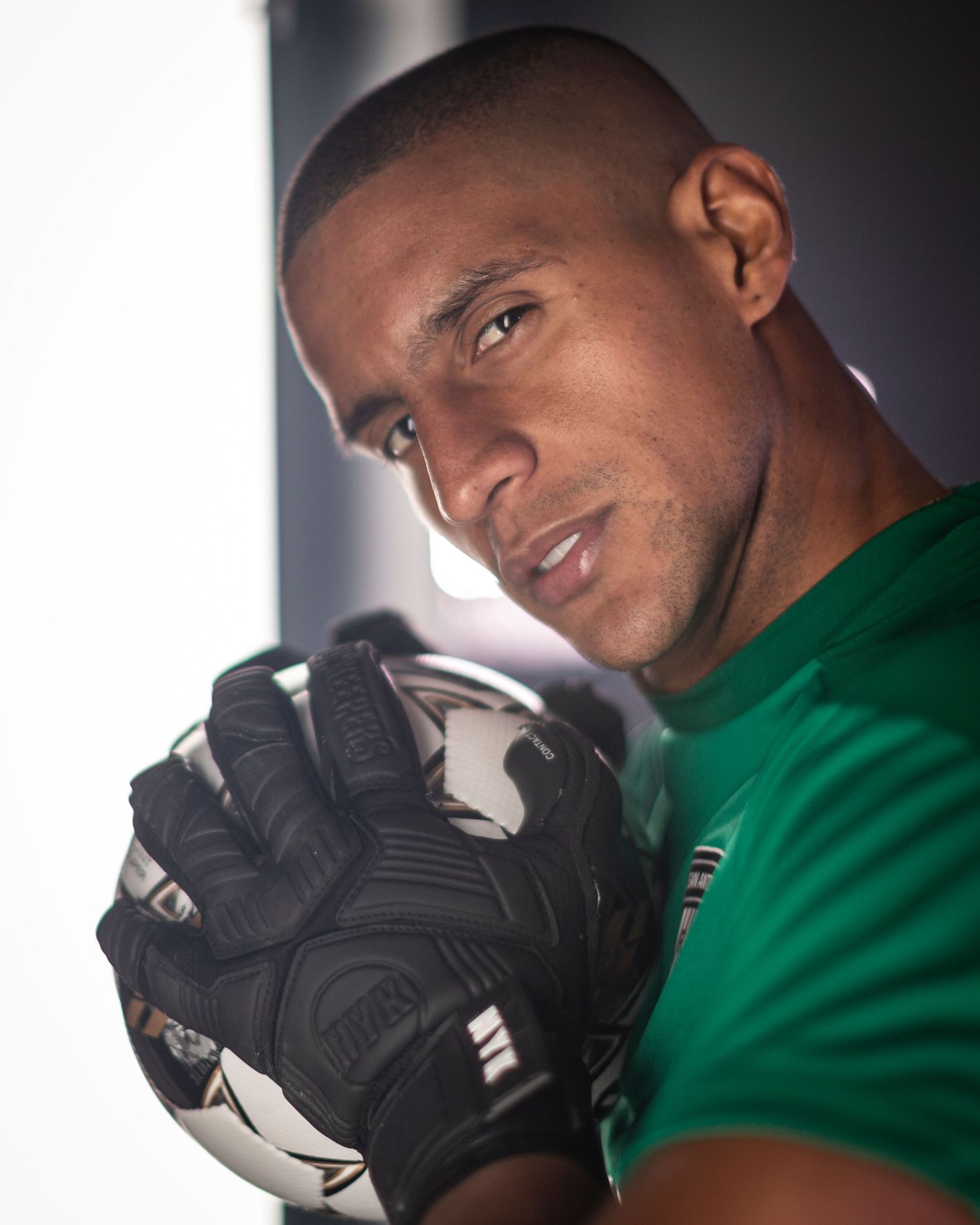 Athletic figure wearing a green shirt and black gloves poses against a dark background in multiple shots.