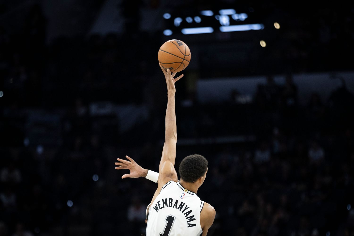 Basketball players compete for the ball during an intense game on a professional court.