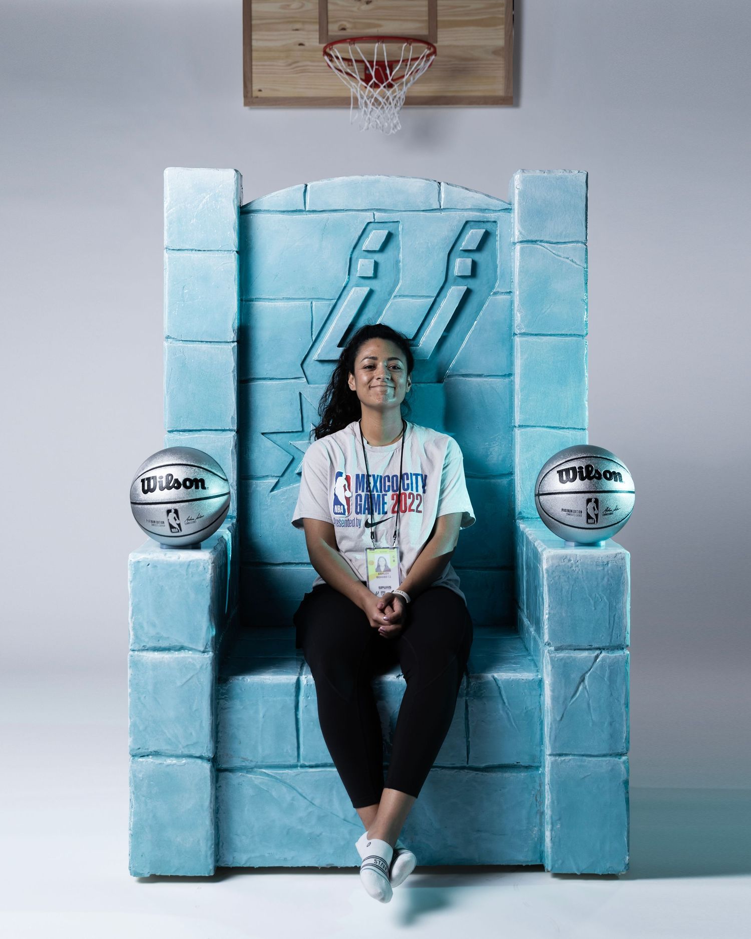 A series of five similar photos showing someone sitting against a turquoise tiled wall with a basketball.