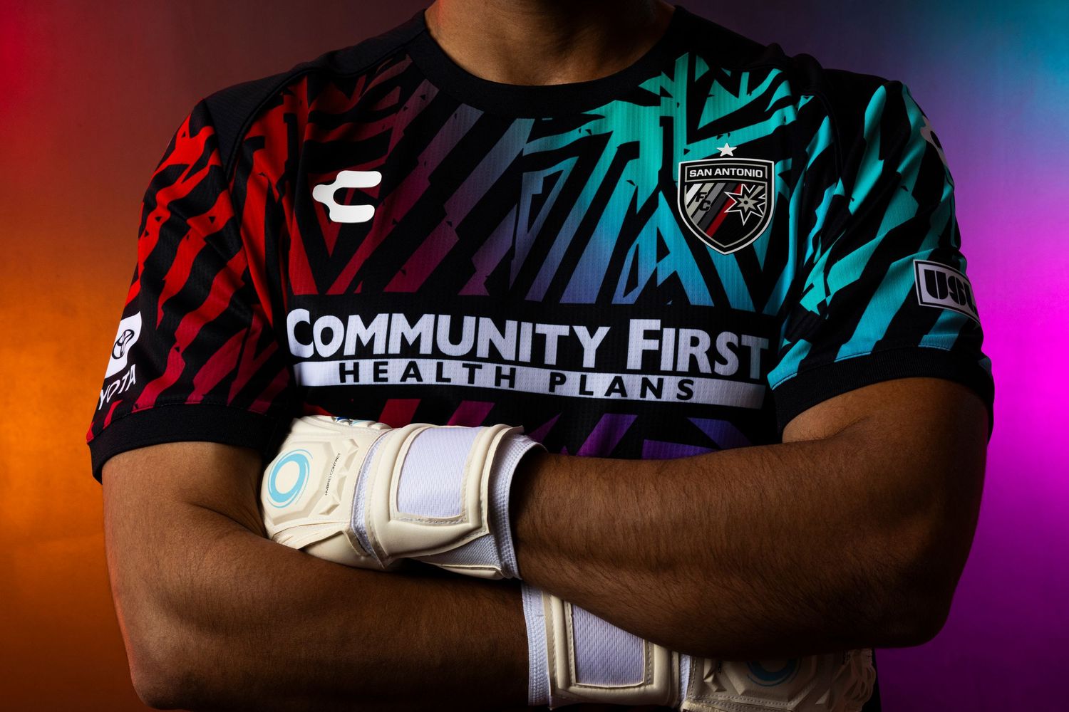 Close-up of soccer jersey with Community First logo in red and blue gradient design.