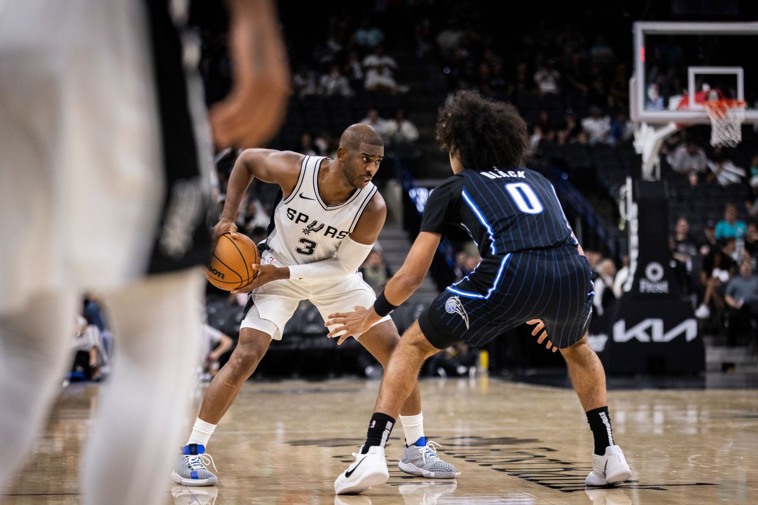 Basketball players engage in defensive positioning during a game. Chris Paul