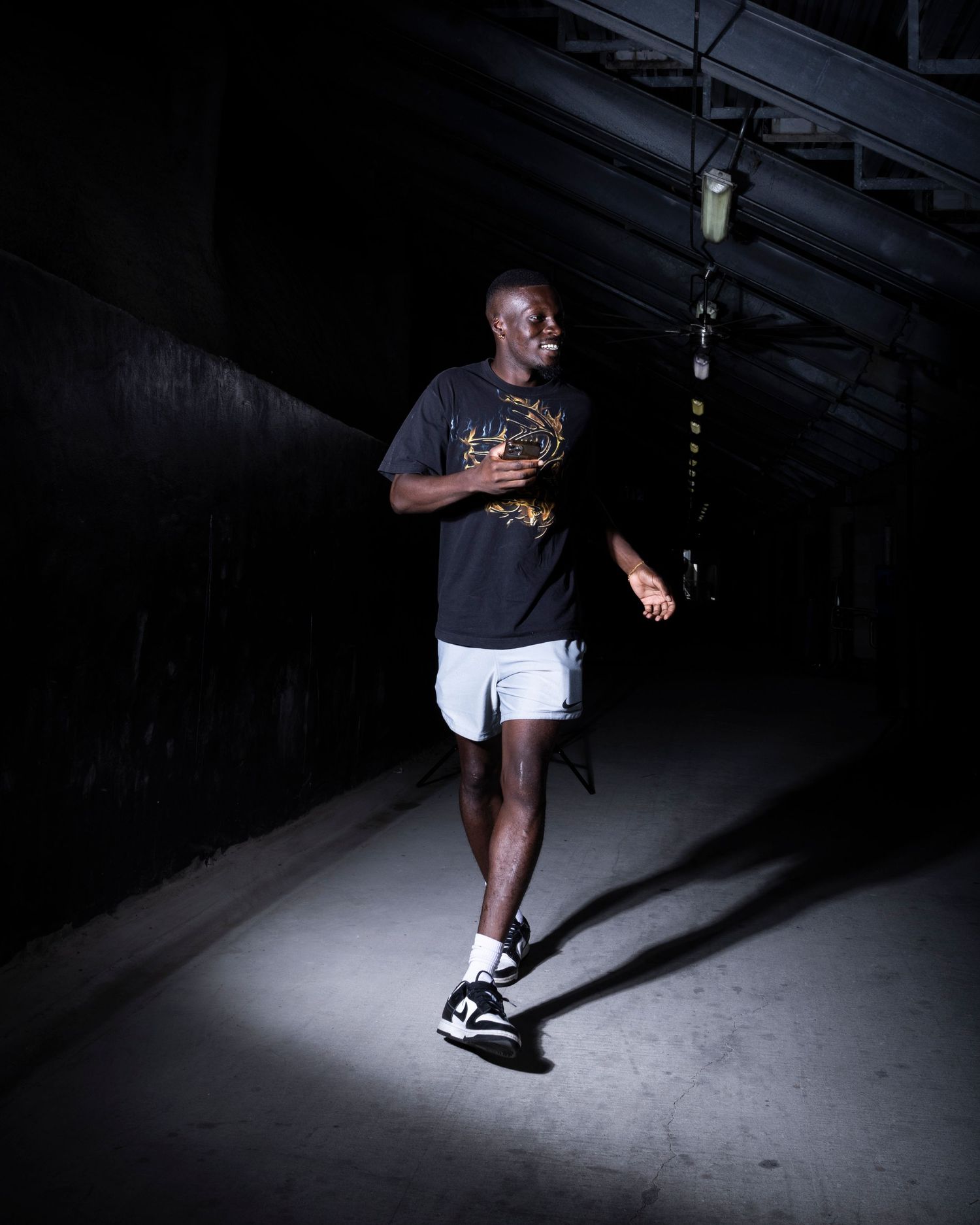 Dramatic spotlit sequence shows an athlete in motion against a dark background.