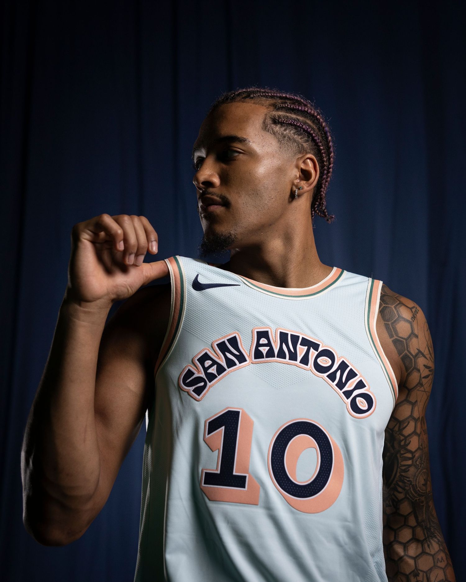 Basketball player in San Antonio number 10 jersey poses in profile view with arm raised. San Antonio Spurs forward Jeremy Sochan, NBA player